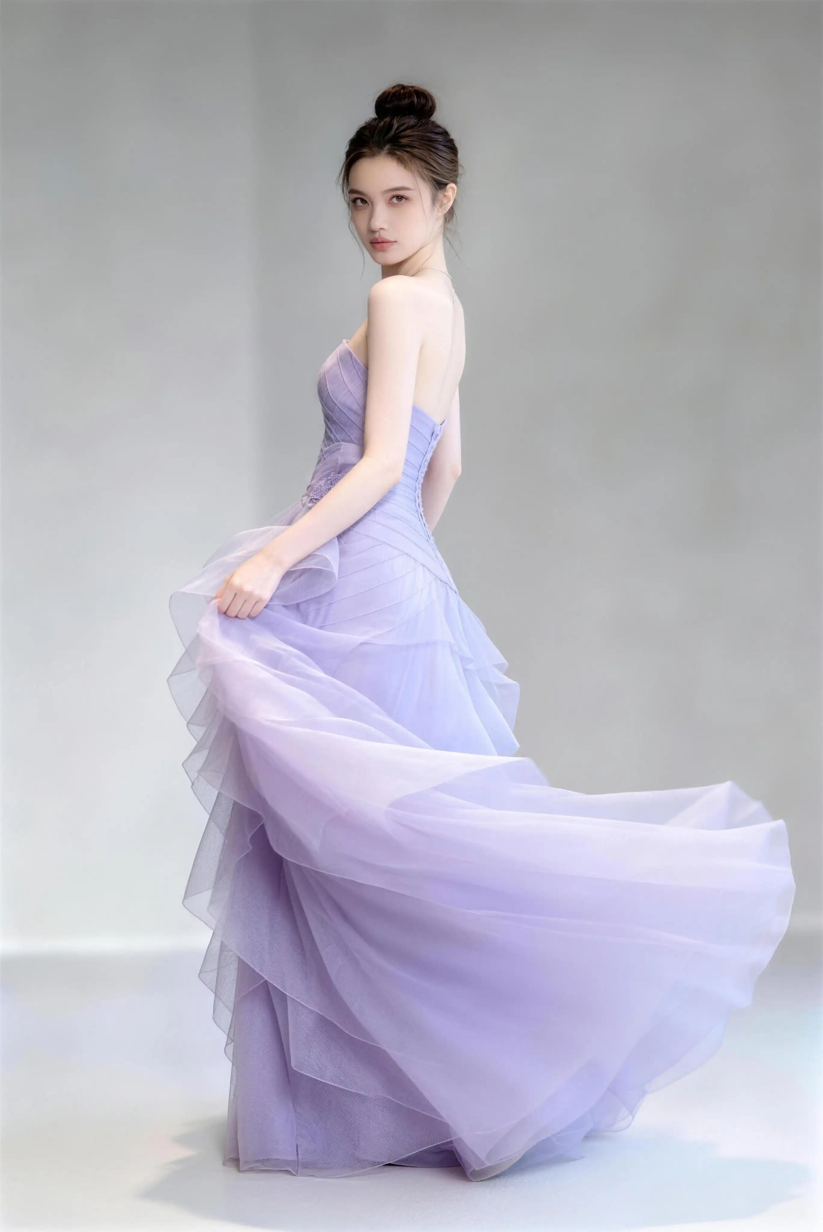 Model wearing light purple strapless ruffle tulle mermaid formal evening gown