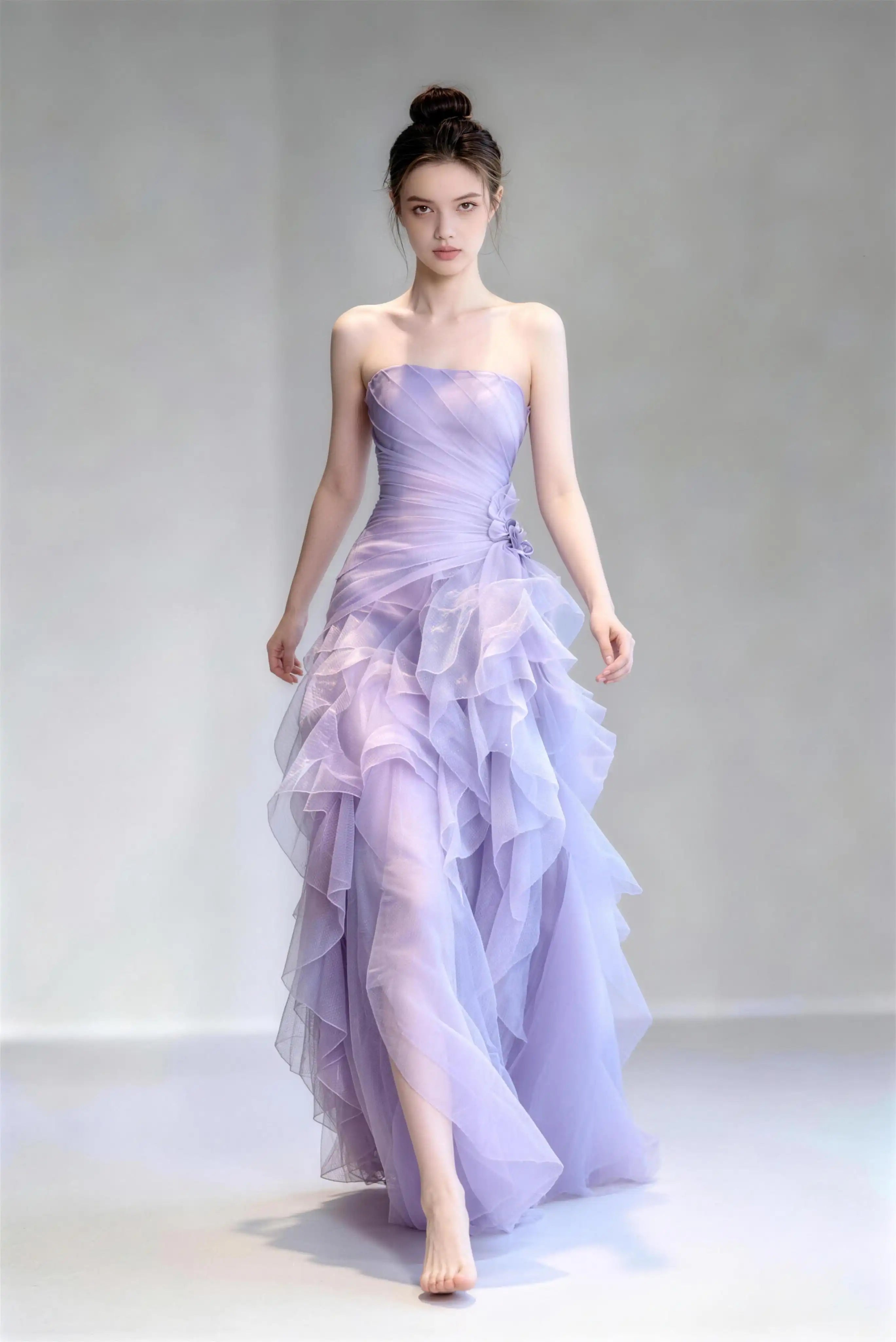 Model wearing light purple strapless ruffle tulle mermaid formal evening gown
