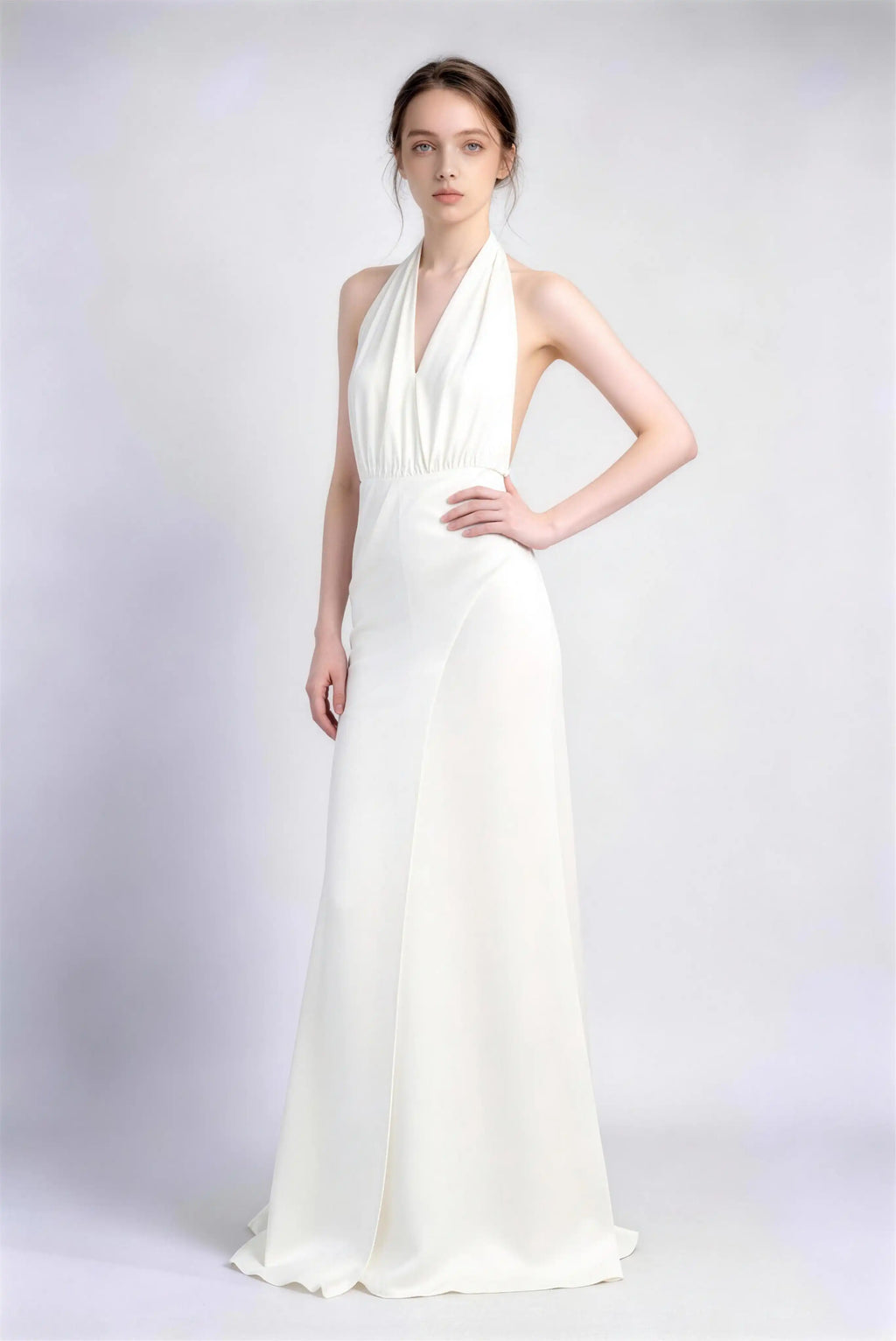 Model wearing white halter open‑back satin formal evening gown