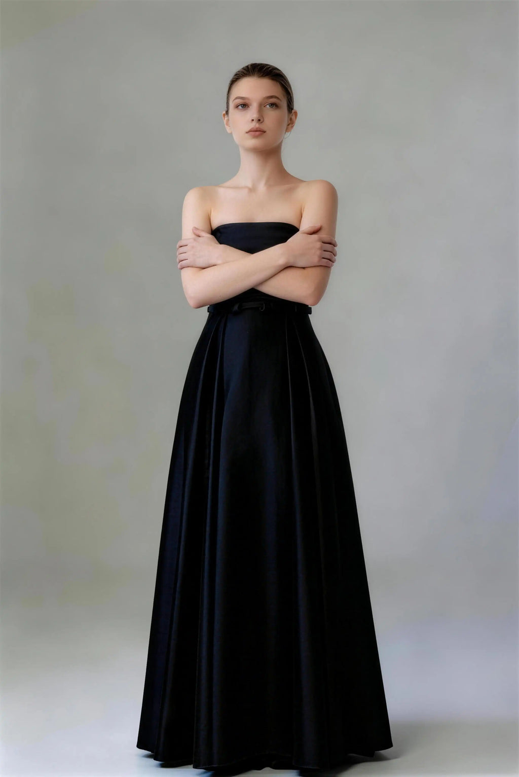 Model wearing black strapless lace‑up back satin formal evening gown
