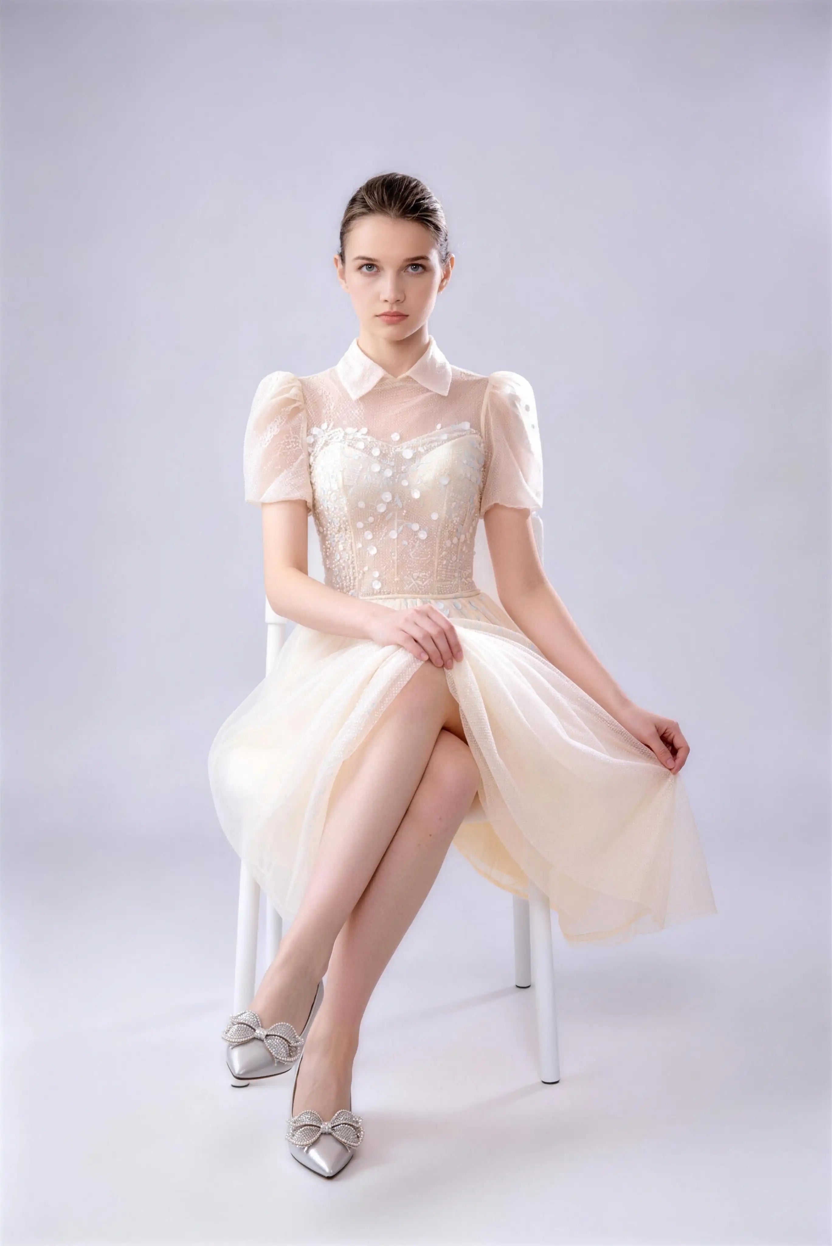Model wearing champagne collared puff sleeve beaded tulle midi formal dress