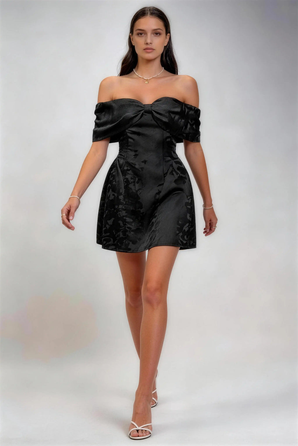 Model wearing white off‑shoulder bow jacquard satin mini formal dress