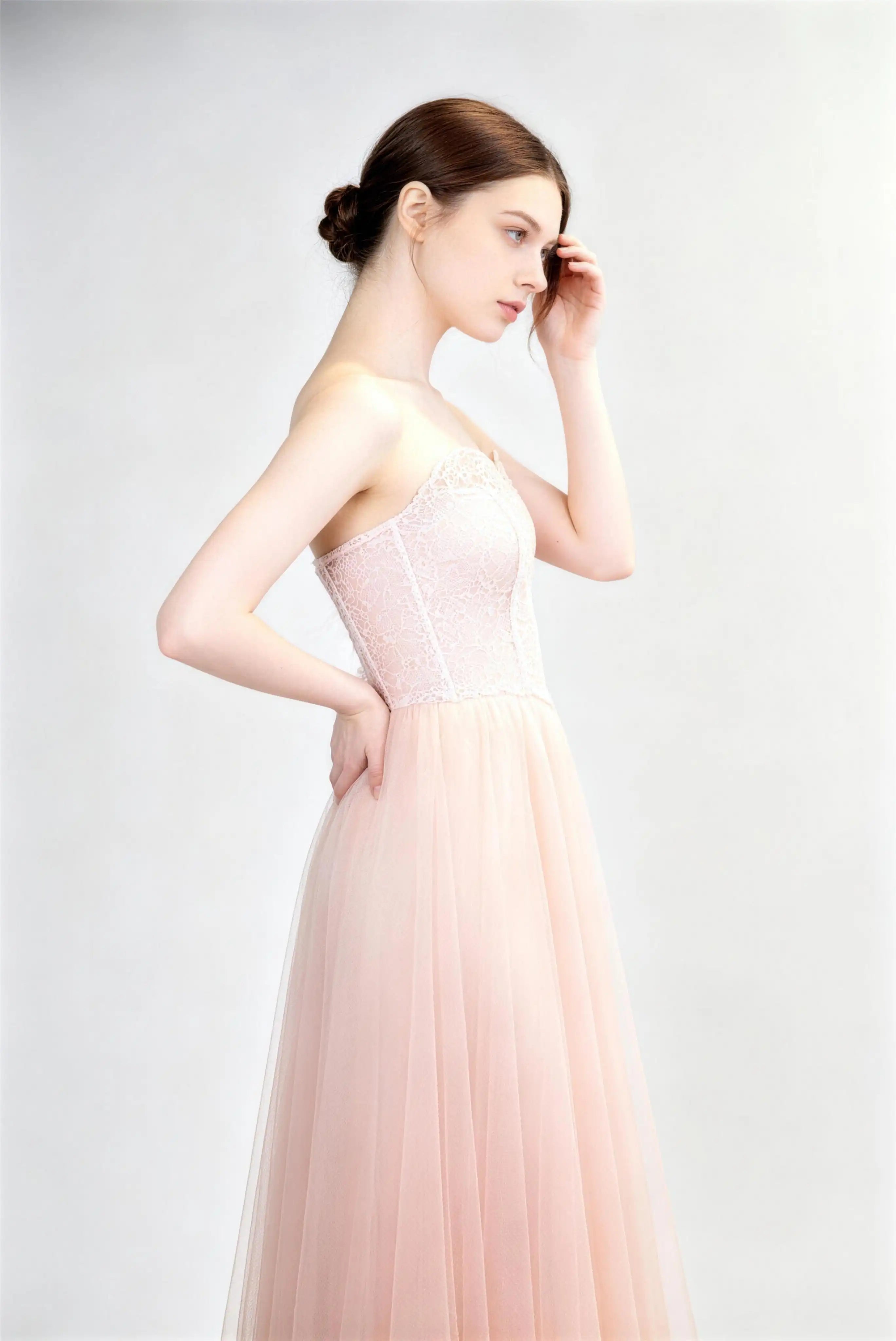 Model wearing light pink strapless lace corset tulle formal evening gown