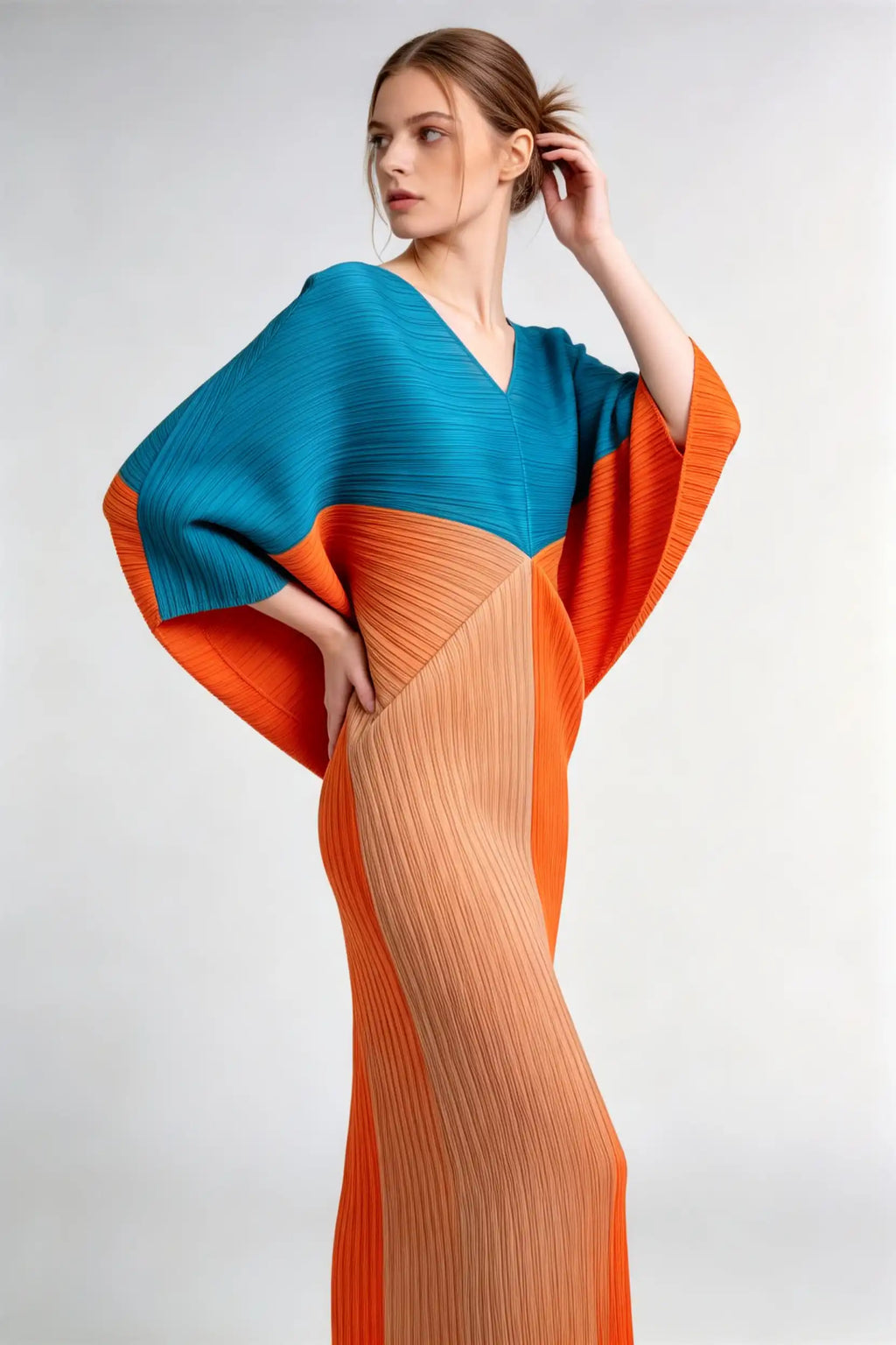 Model wearing blue contrast color block pleated batwing sleeve midi dress