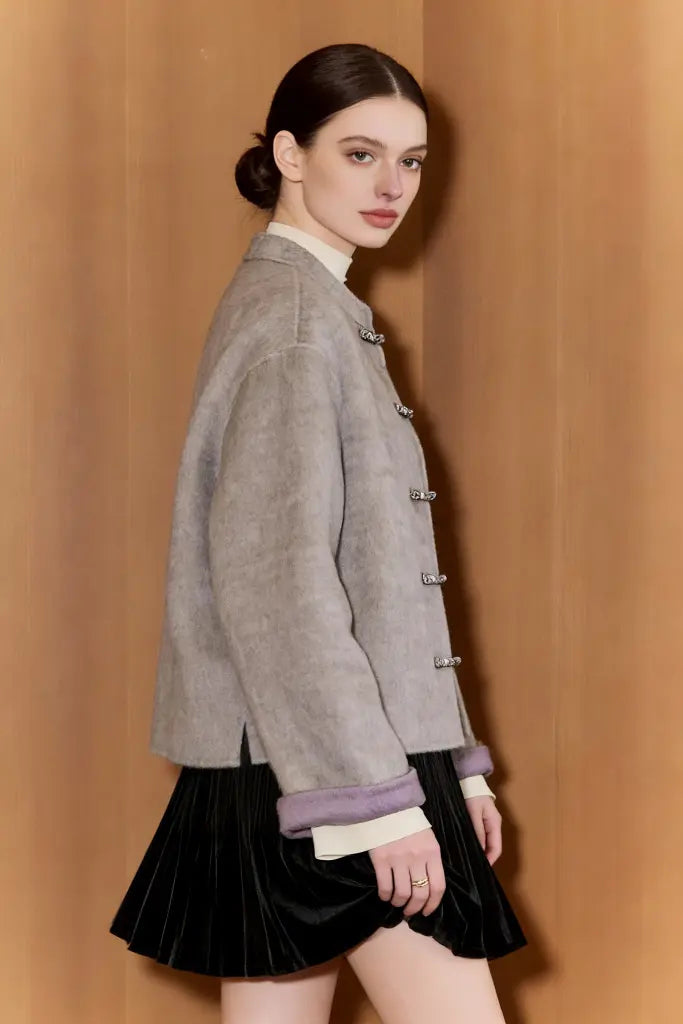 Woman wearing a gray jacket with a brown background