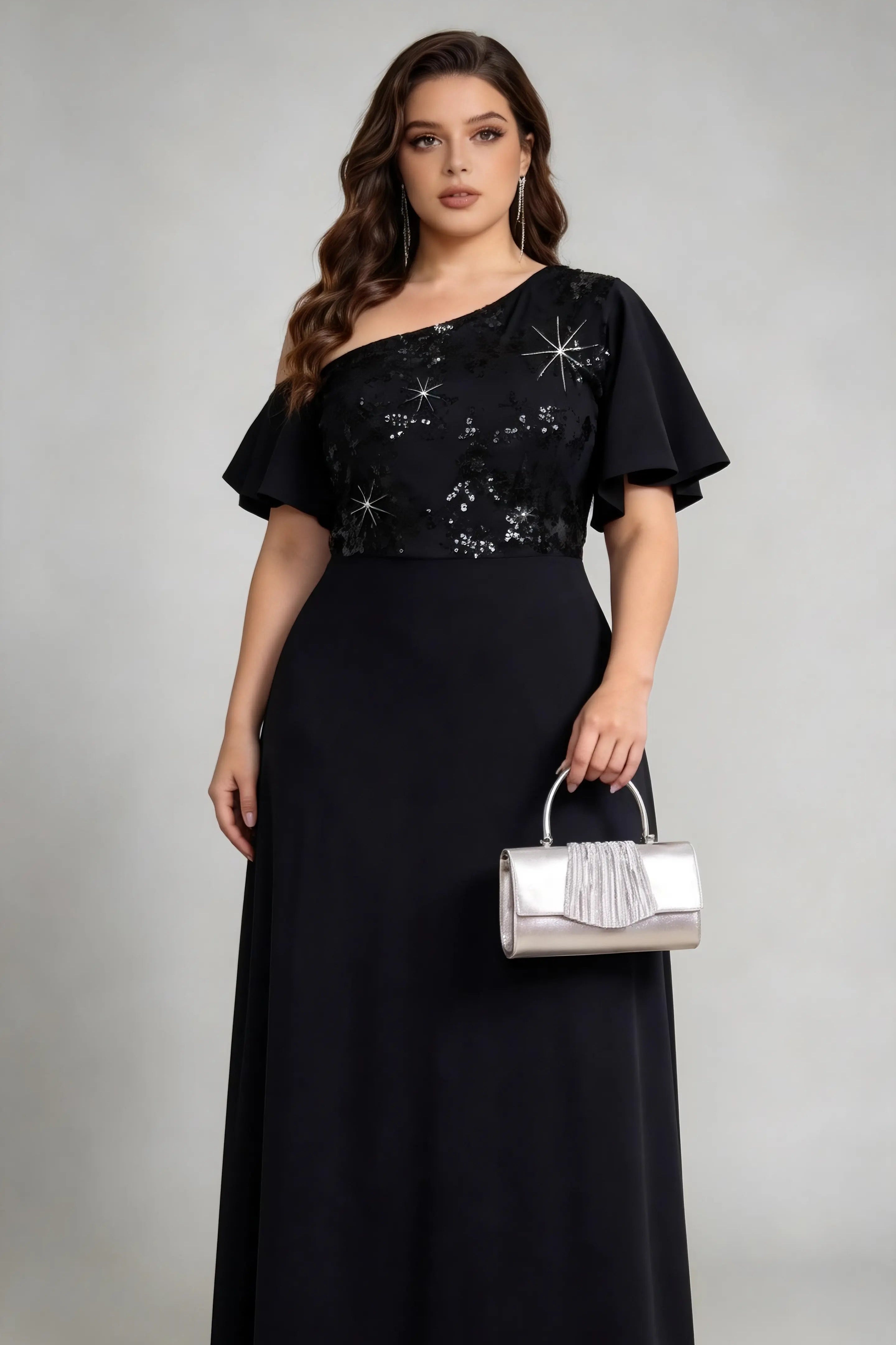 Plus size woman wearing black one-shoulder sequin evening gown with silver clutch bag, full-length view