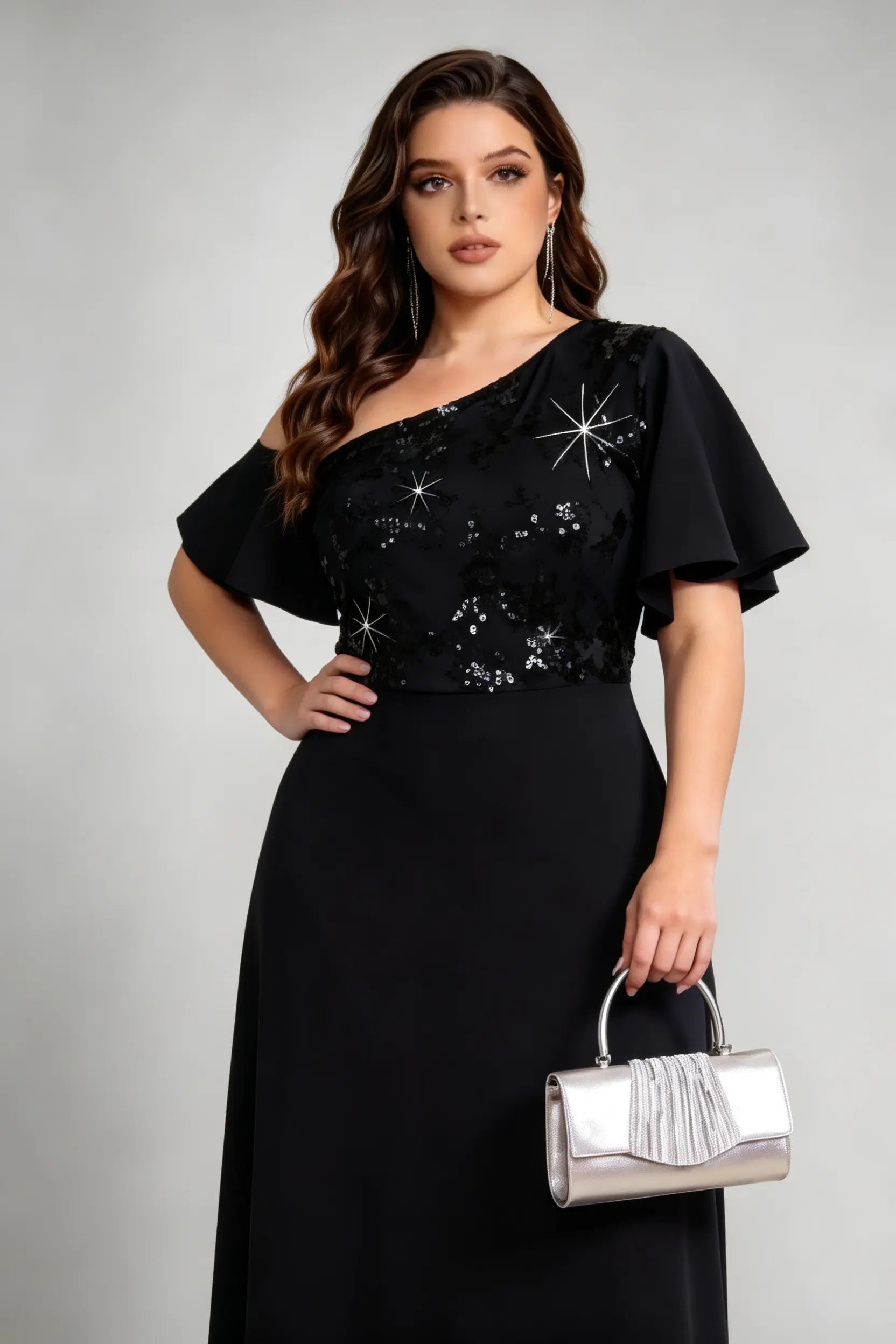 Plus size woman wearing black sequin one-shoulder gown with hand on hip