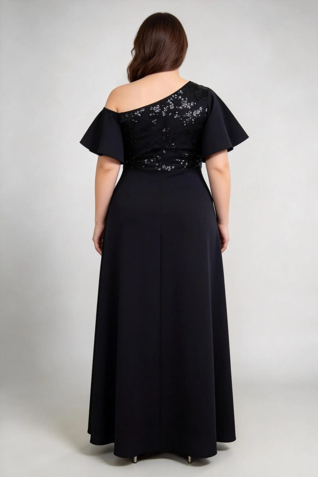 Plus size woman wearing back view of black one-shoulder evening gown with flutter sleeves