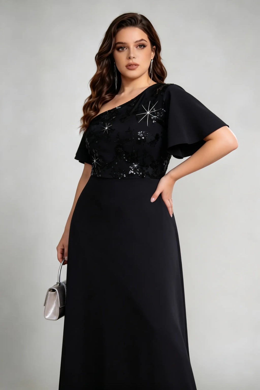 Side view of black one-shoulder gown with plus size woman holding silver clutch