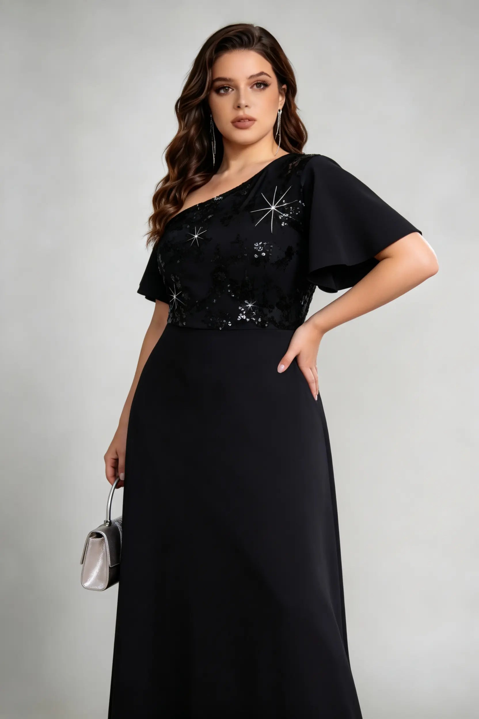 Side view of black one-shoulder gown with plus size woman holding silver clutch