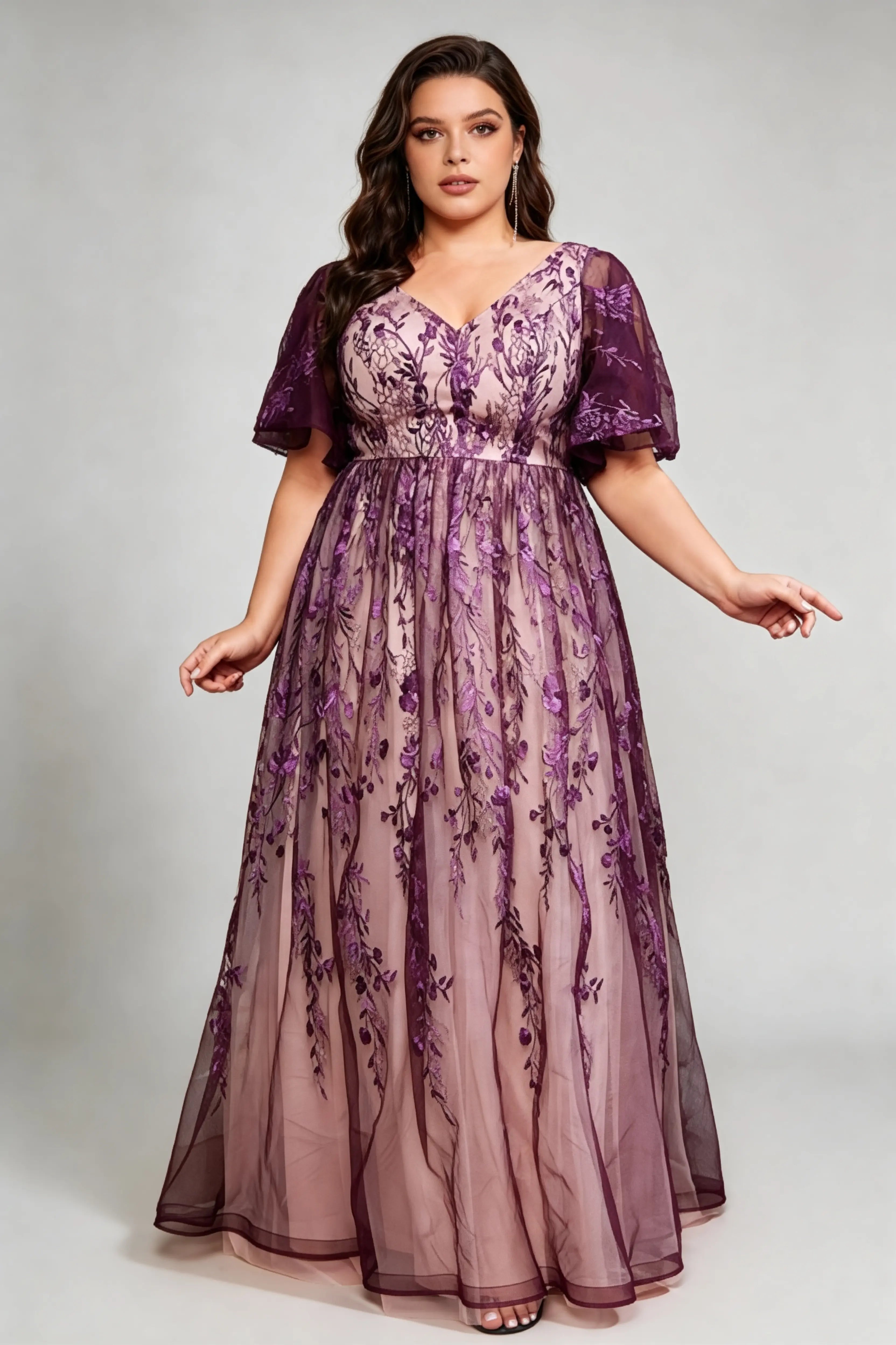 Curvy model wearing plus size v-neck embroidered mesh maxi dress - elegant purple floral flutter sleeve evening gown