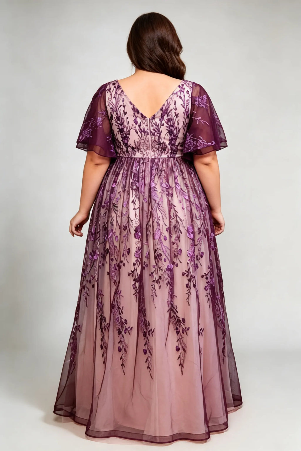 Curvy model wearing plus size v-neck embroidered mesh maxi dress - elegant purple floral flutter sleeve evening gown