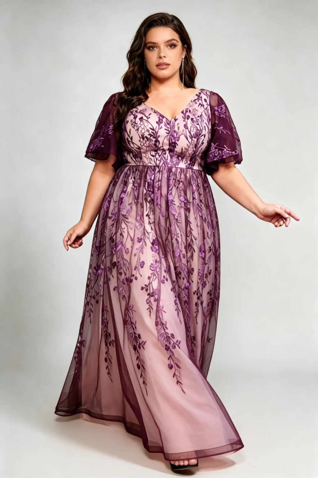 Curvy model wearing plus size v-neck embroidered mesh maxi dress - elegant purple floral flutter sleeve evening gown