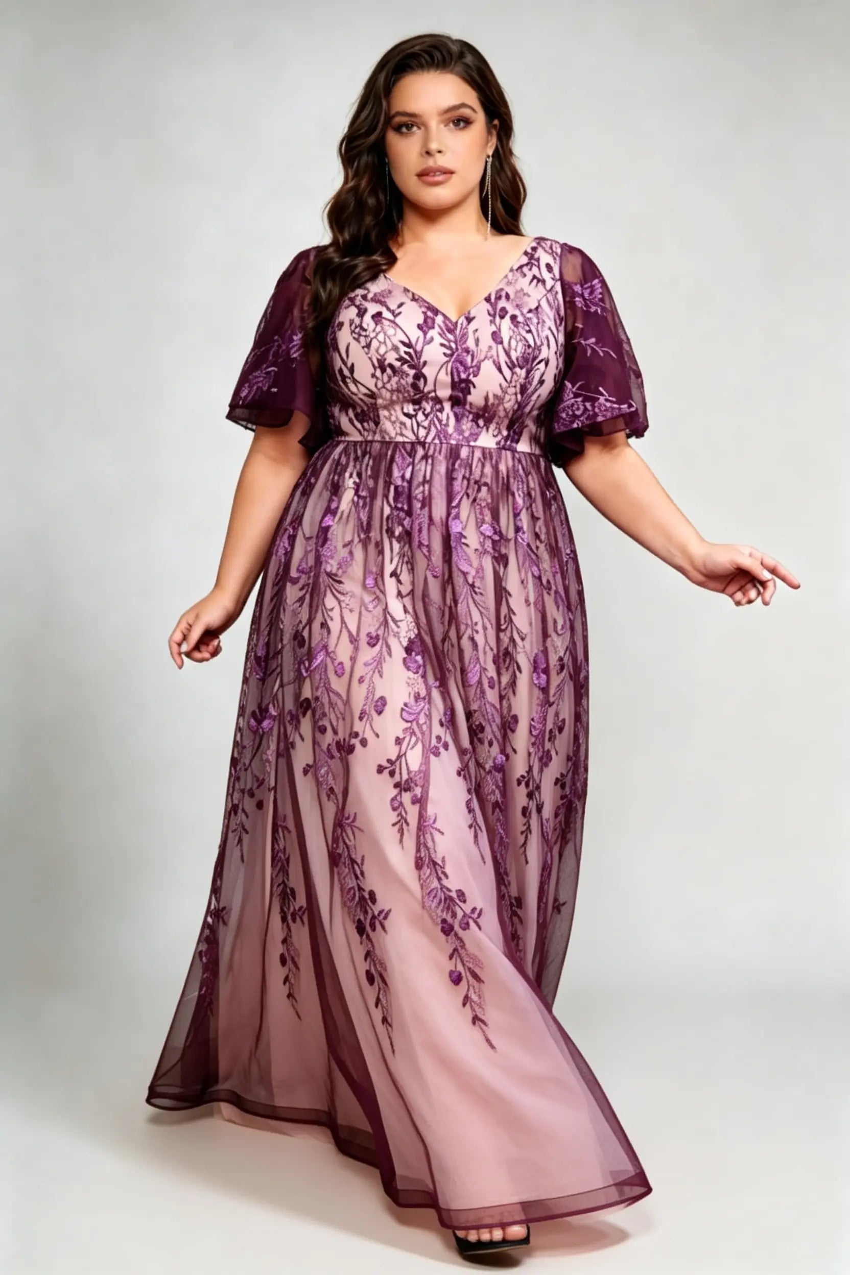 Curvy model wearing plus size v-neck embroidered mesh maxi dress - elegant purple floral flutter sleeve evening gown