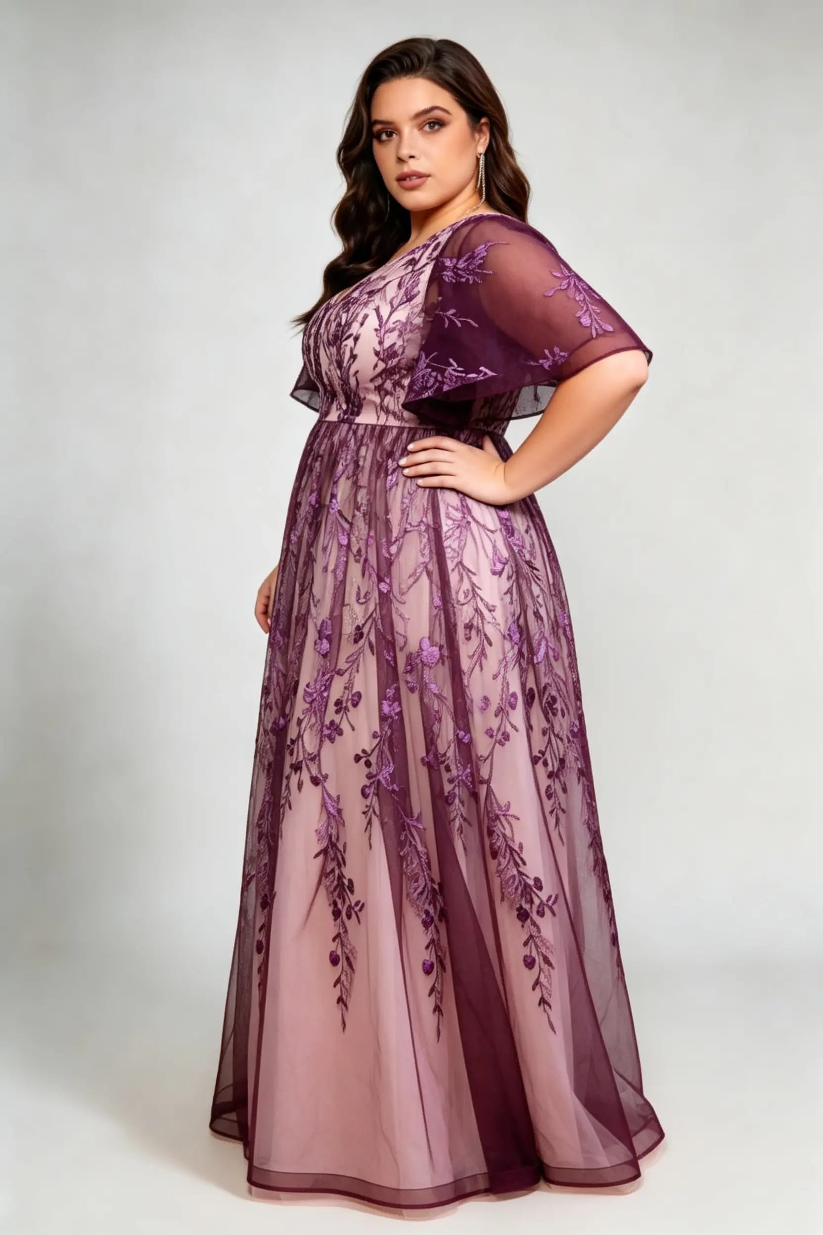 Curvy model wearing plus size v-neck embroidered mesh maxi dress - elegant purple floral flutter sleeve evening gown