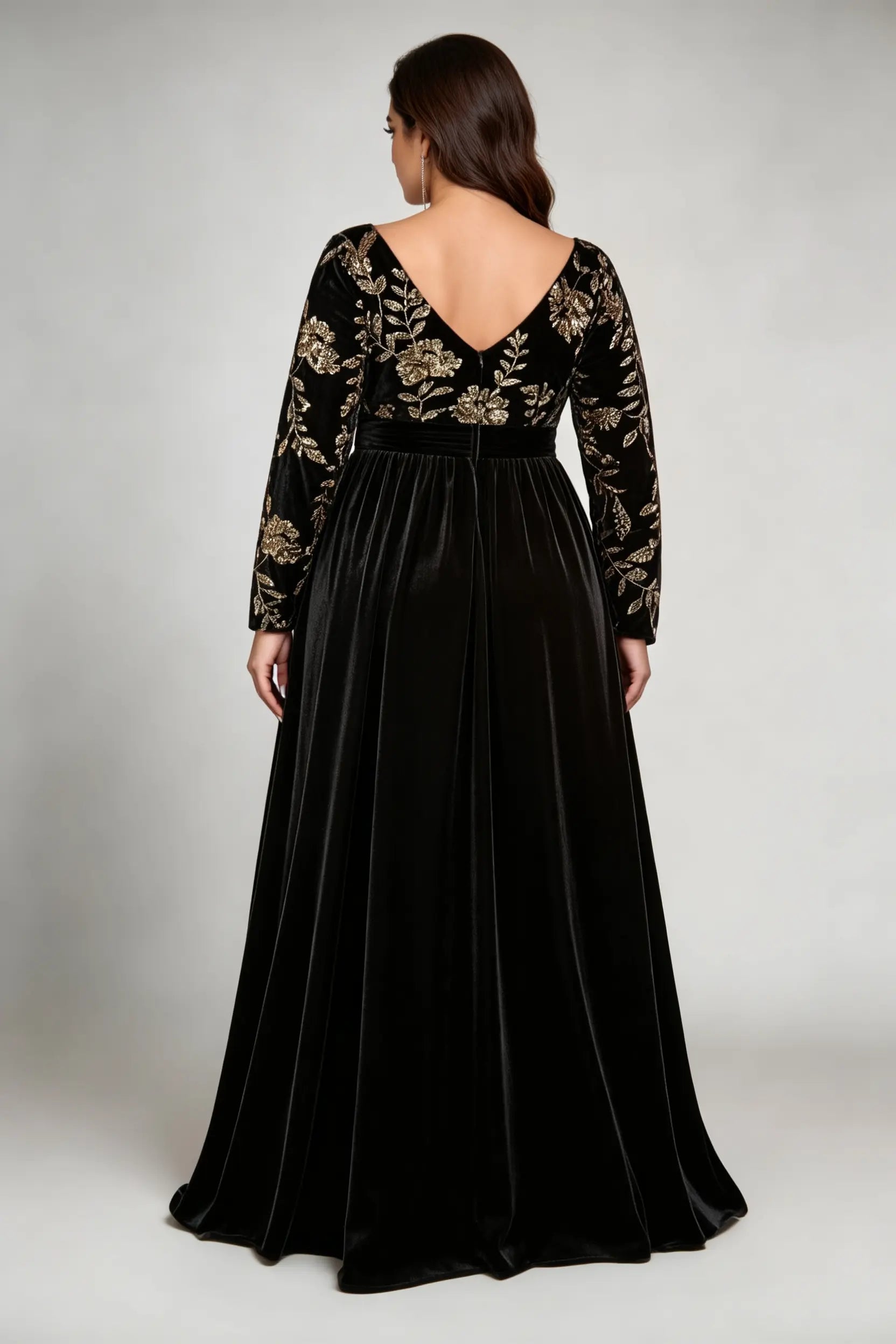 Curvy model wearing plus size black elegant v-neck velvet maxi dress with gold floral embroidery