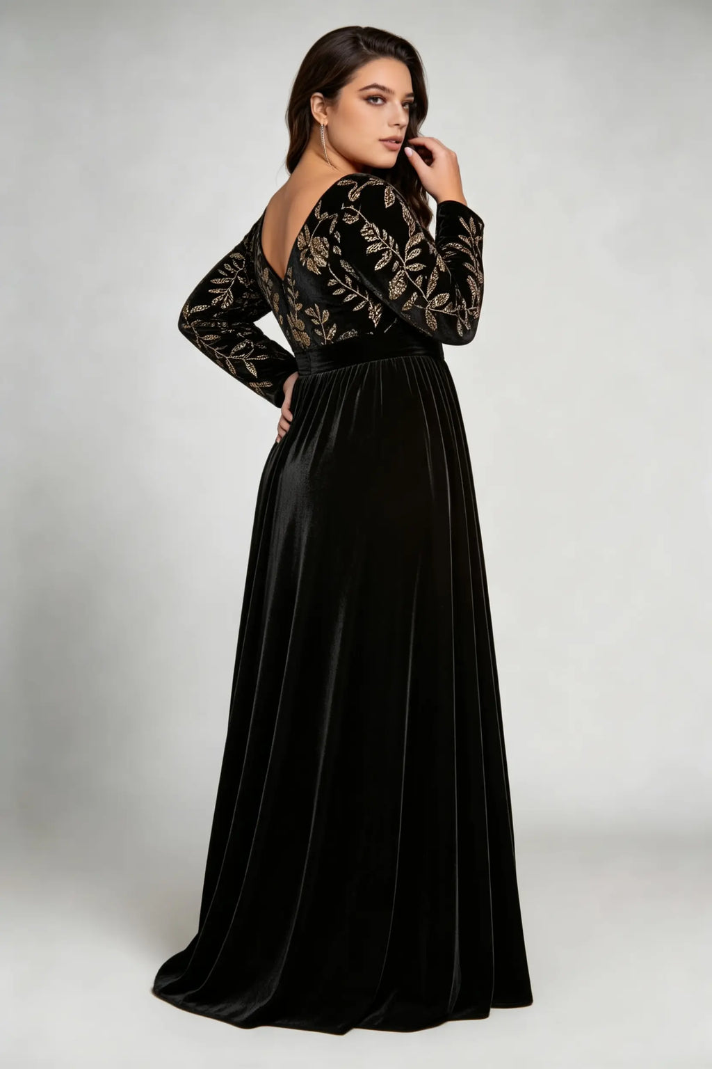 Curvy model wearing plus size black elegant v-neck velvet maxi dress with gold floral embroidery