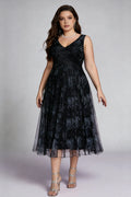 Curvy model wearing plus size black surplice v-neck floral mesh midi dress