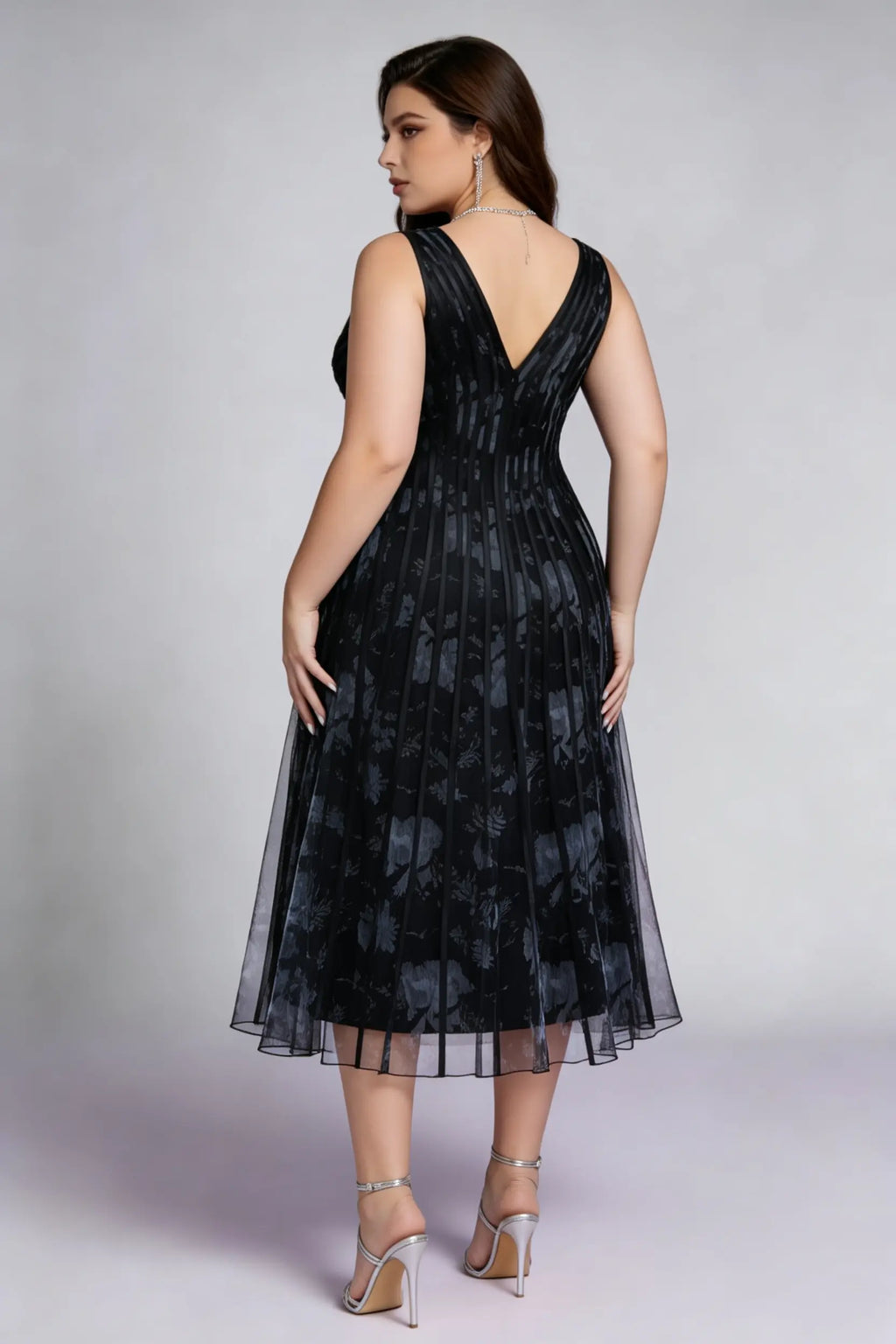 Curvy model wearing plus size black surplice v-neck floral mesh midi dress