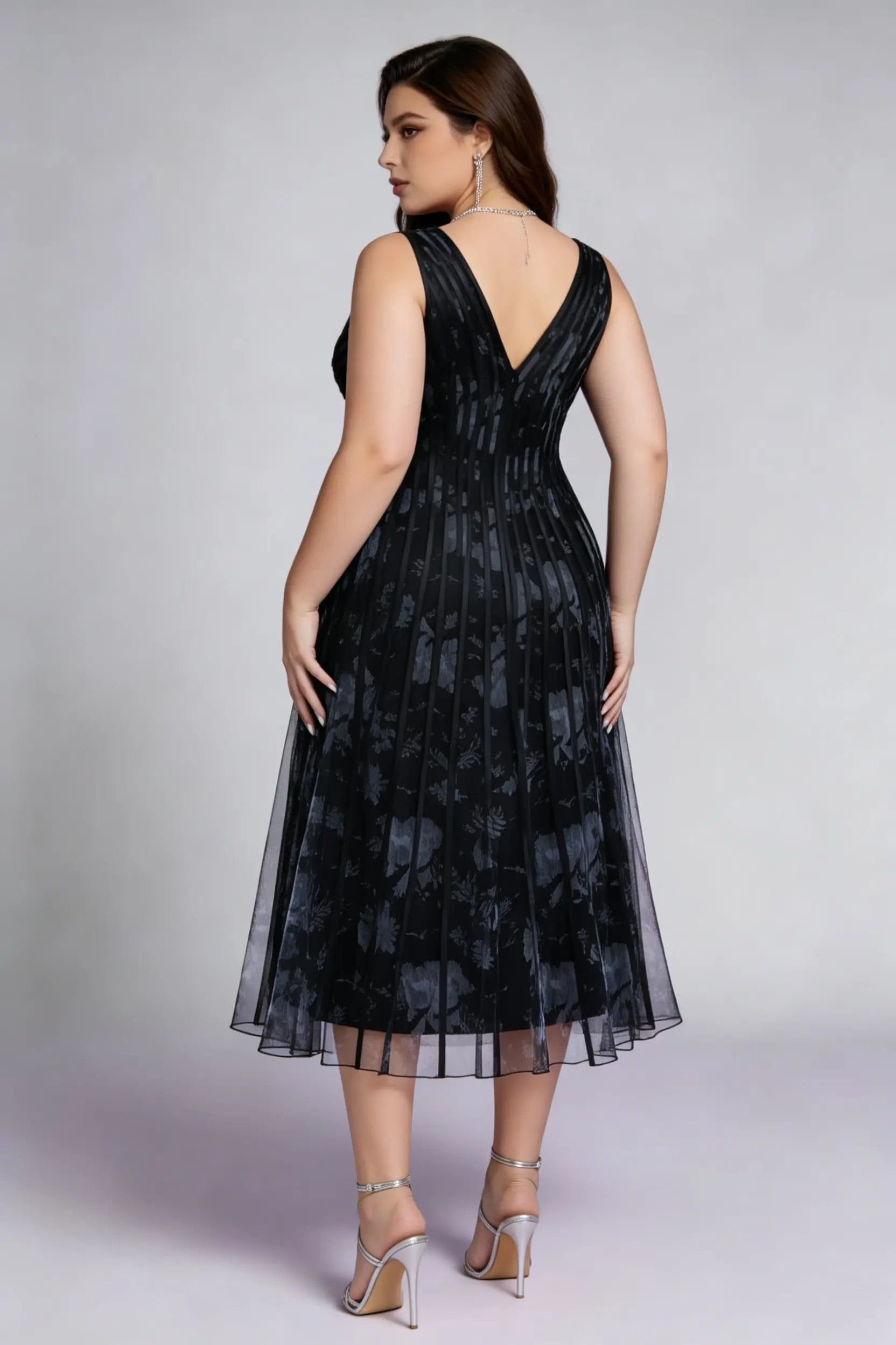 Curvy model wearing plus size black surplice v-neck floral mesh midi dress