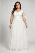 Curvy model wearing plus size white v-neck embroidered chiffon maxi wedding dress with flutter sleeves