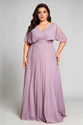 Curvy model wearing plus size purple v-neck pleated chiffon maxi evening dress with flutter sleeves
