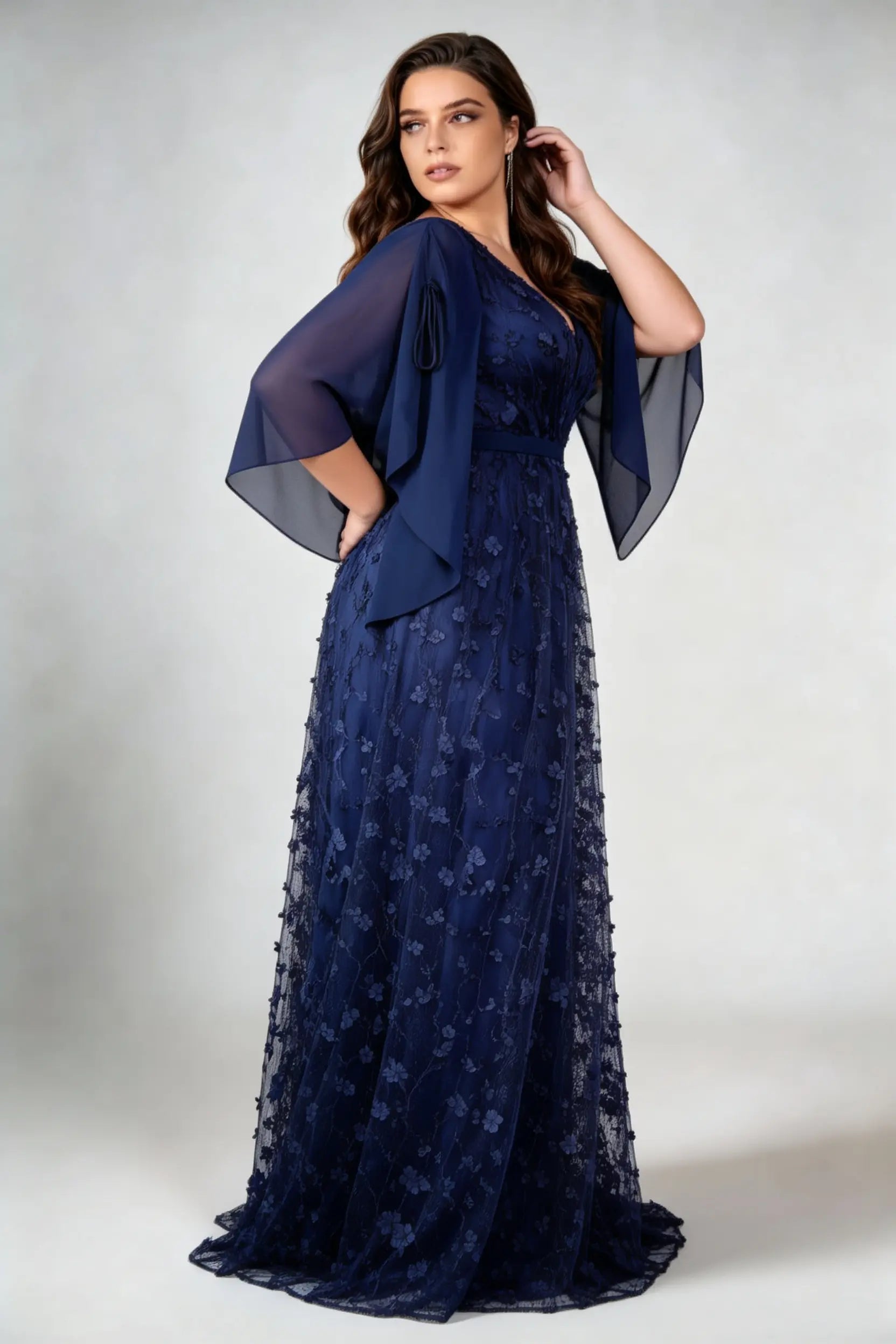 Curvy model wearing plus size navy blue 3d floral applique evening gown – elegant v-neck cape sleeve formal maxi dress with slit (xl-4xl)