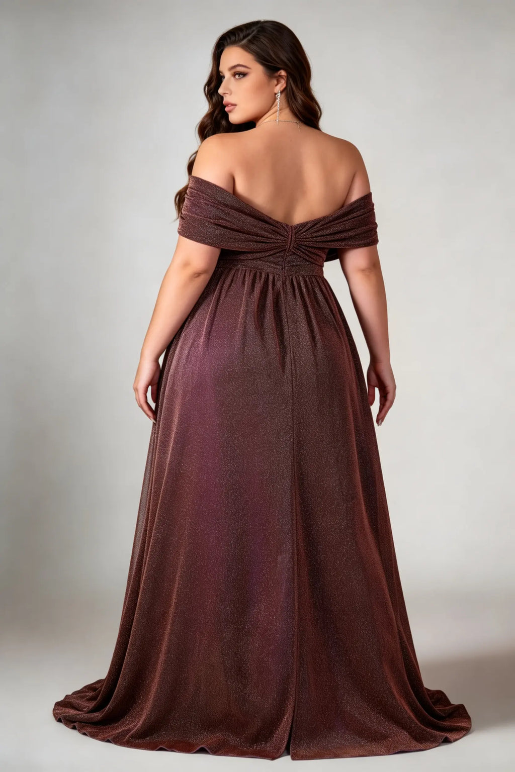 Curvy model wearing plus size brown shimmering off-the-shoulder evening gown – elegant metallic v-neck high slit formal maxi dress