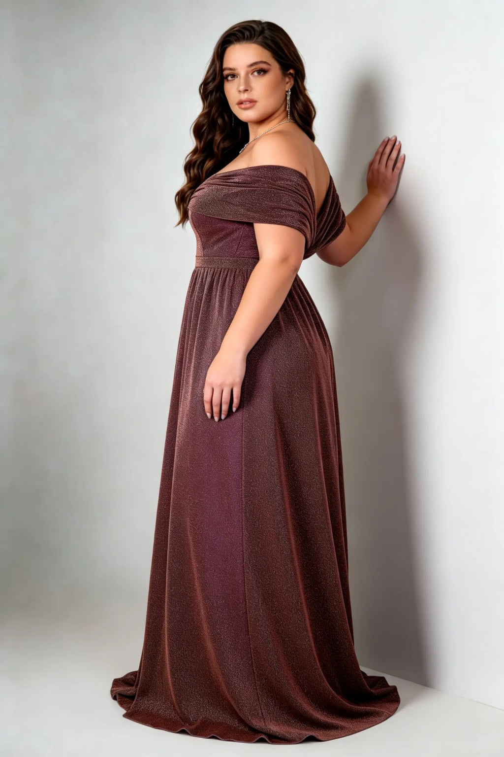 Curvy model wearing plus size brown shimmering off-the-shoulder evening gown – elegant metallic v-neck high slit formal maxi dress