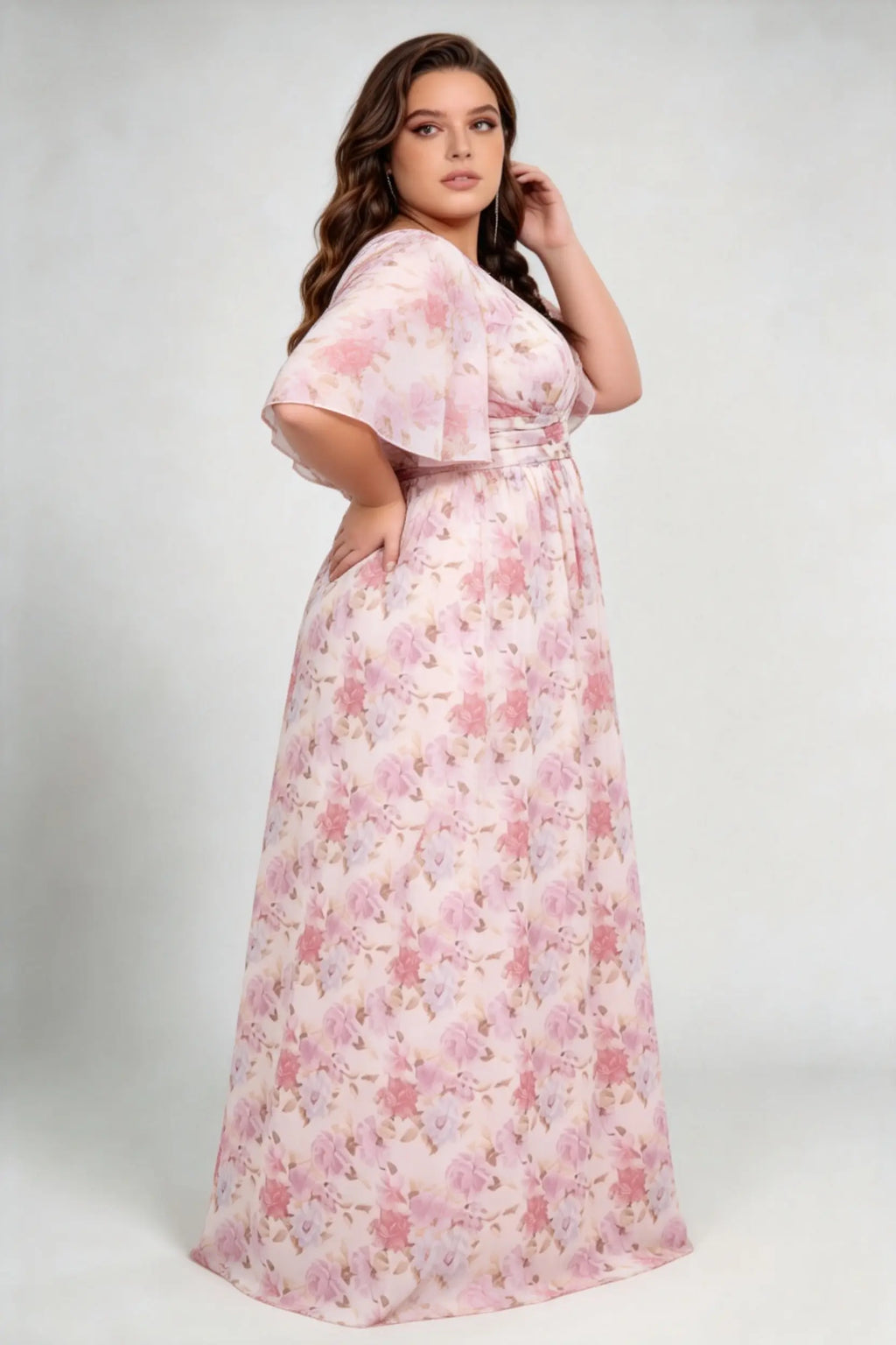 Curvy model wearing plus size pink pastel floral print chiffon evening gown – elegant v-neck flutter sleeve formal maxi dress