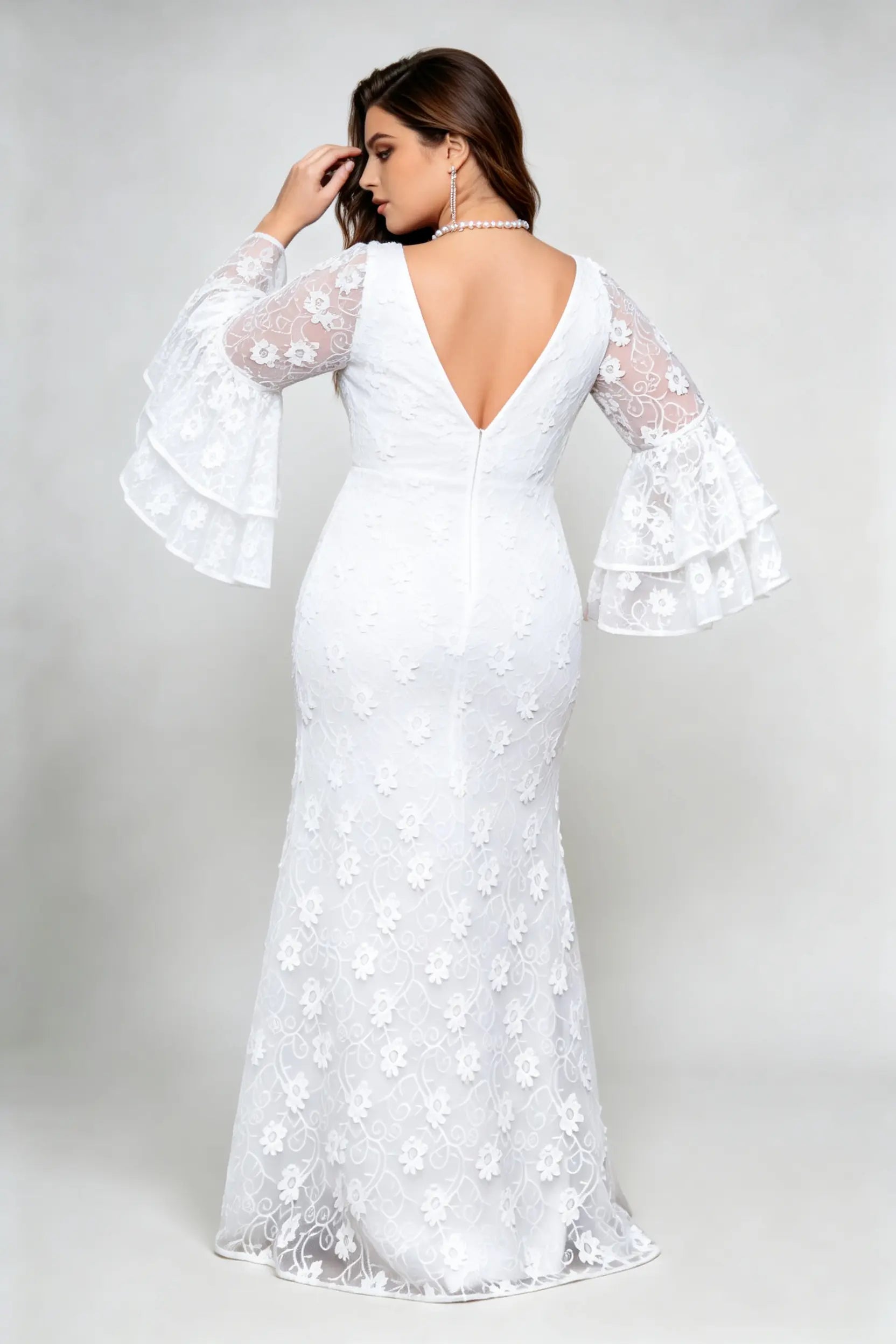 Curvy model wearing plus size v-neck white floral lace maxi dress with tiered bell sleeves