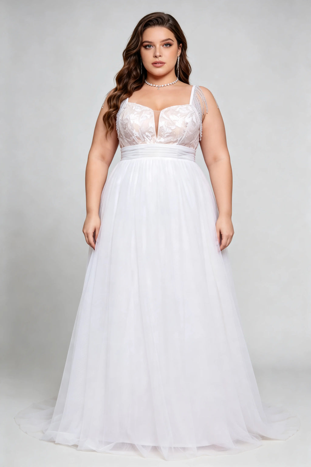 Curvy model wearing plus size white v-neck tulle bridal gown with rhinestone fringe shoulder straps