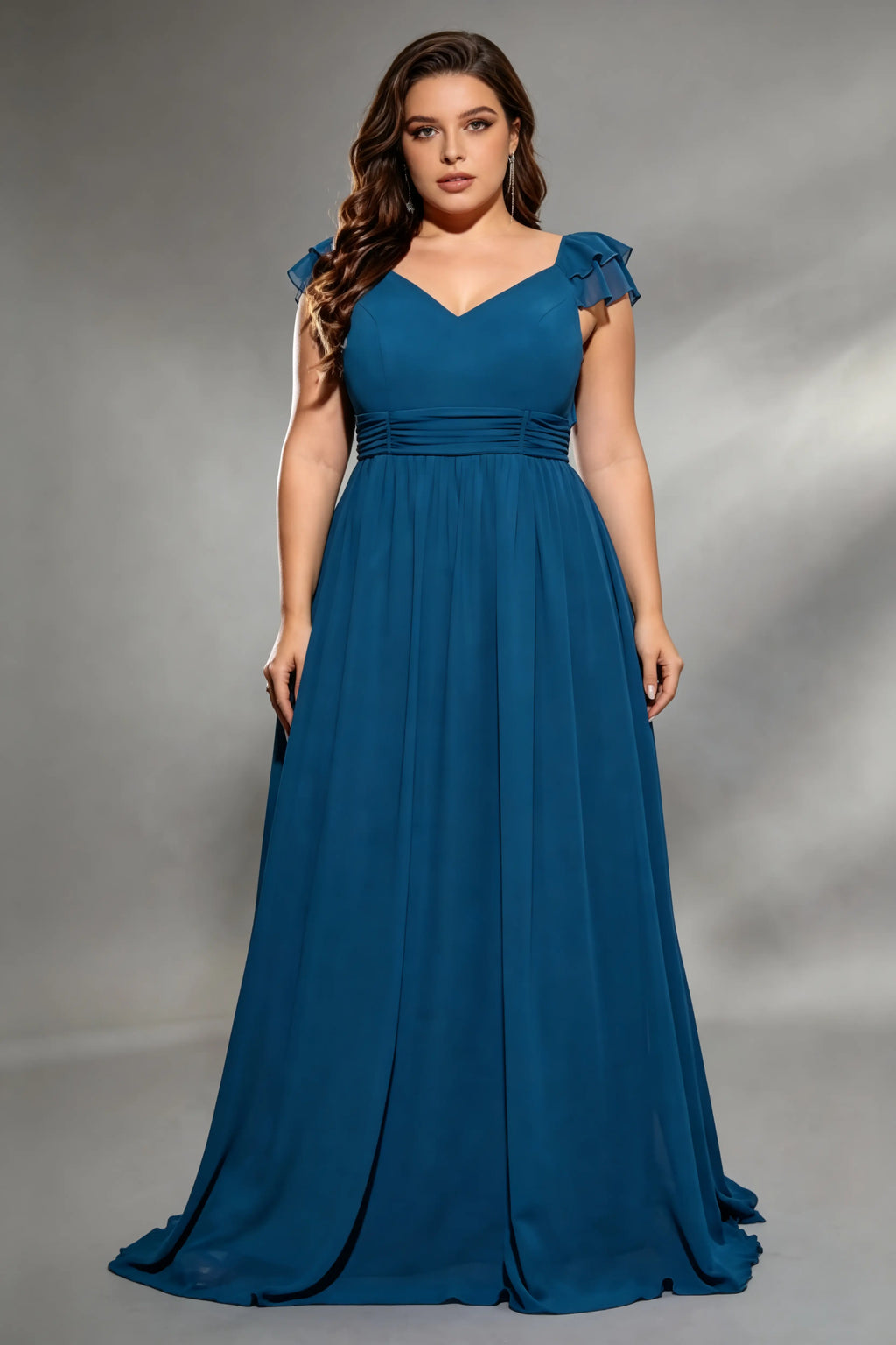 Curvy model wearing plus size navy v-neck teal blue chiffon maxi dress with cascading back ruffles