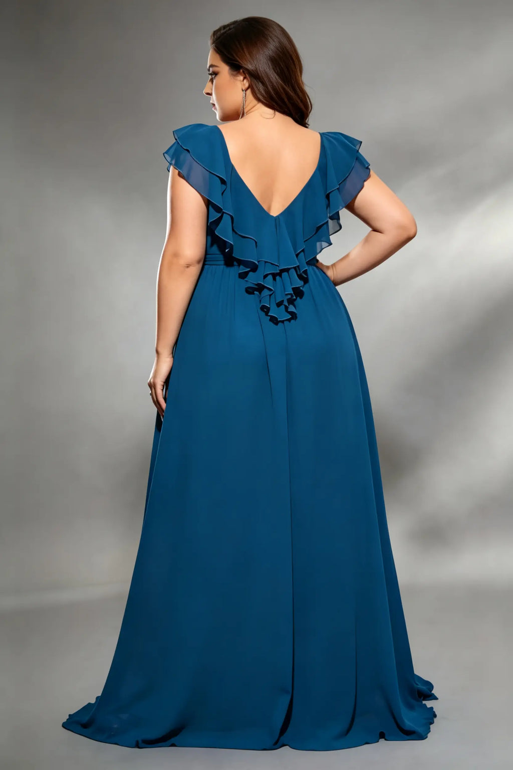 Curvy model wearing plus size navy v-neck teal blue chiffon maxi dress with cascading back ruffles