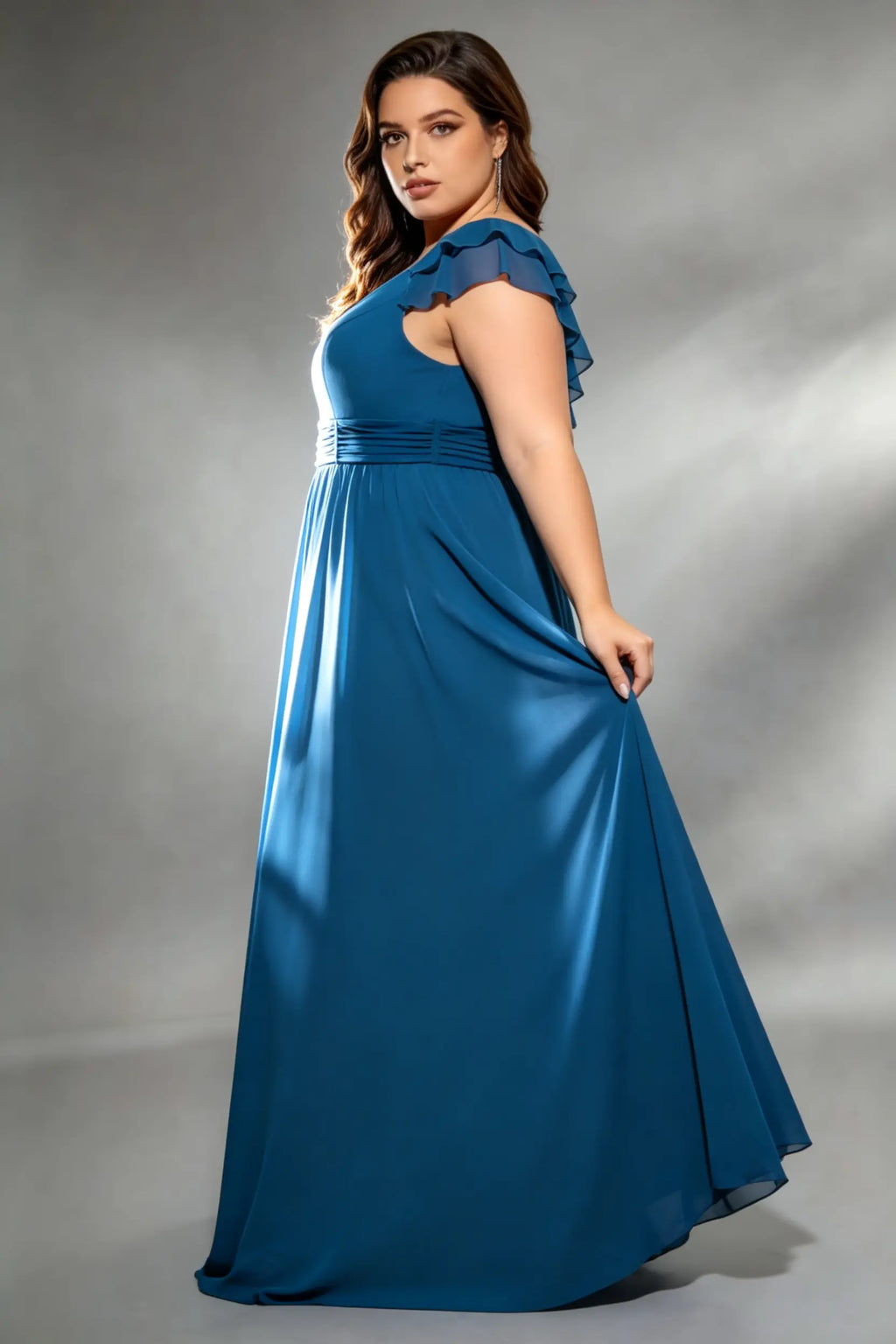 Curvy model wearing plus size navy v-neck teal blue chiffon maxi dress with cascading back ruffles