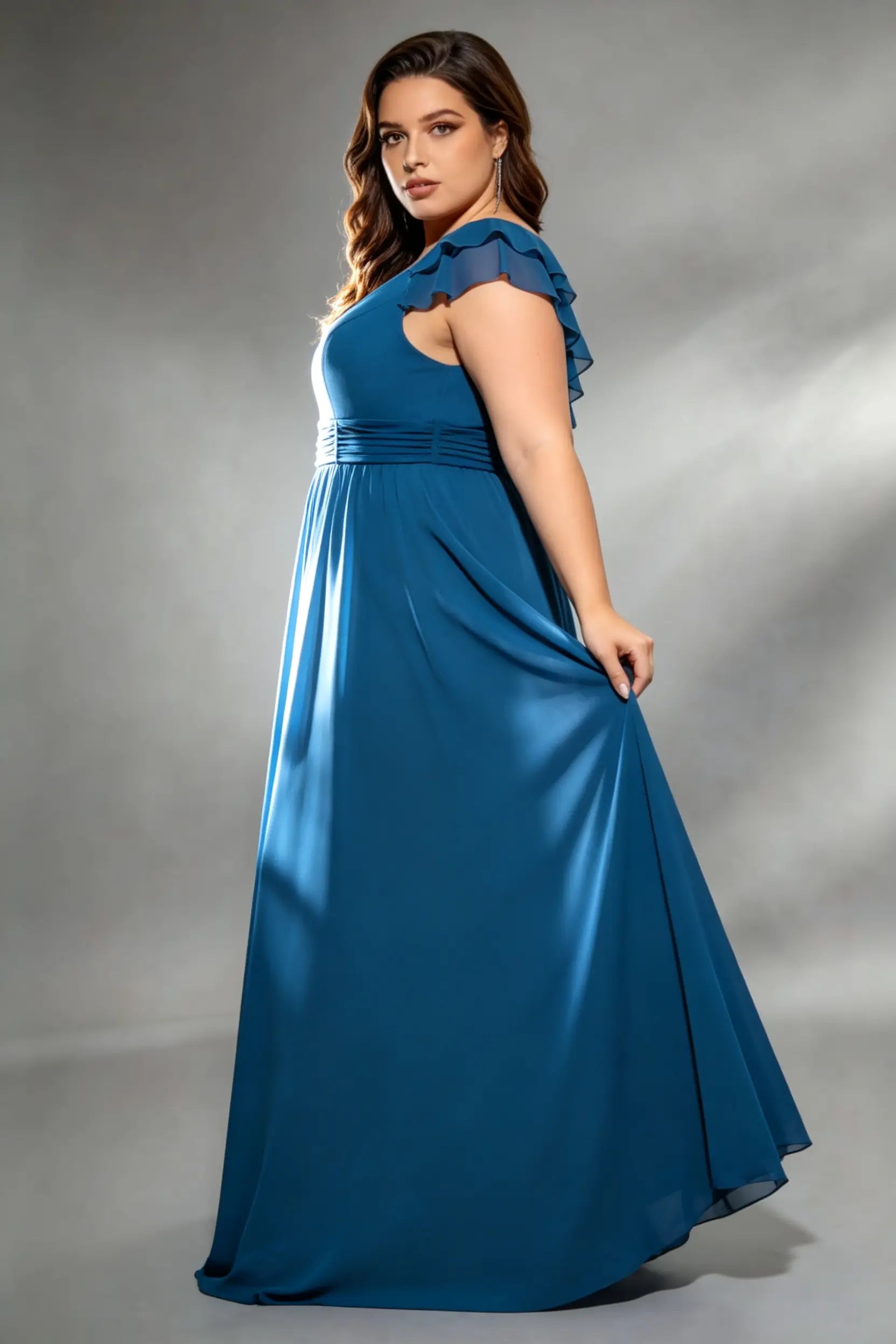Curvy model wearing plus size navy v-neck teal blue chiffon maxi dress with cascading back ruffles