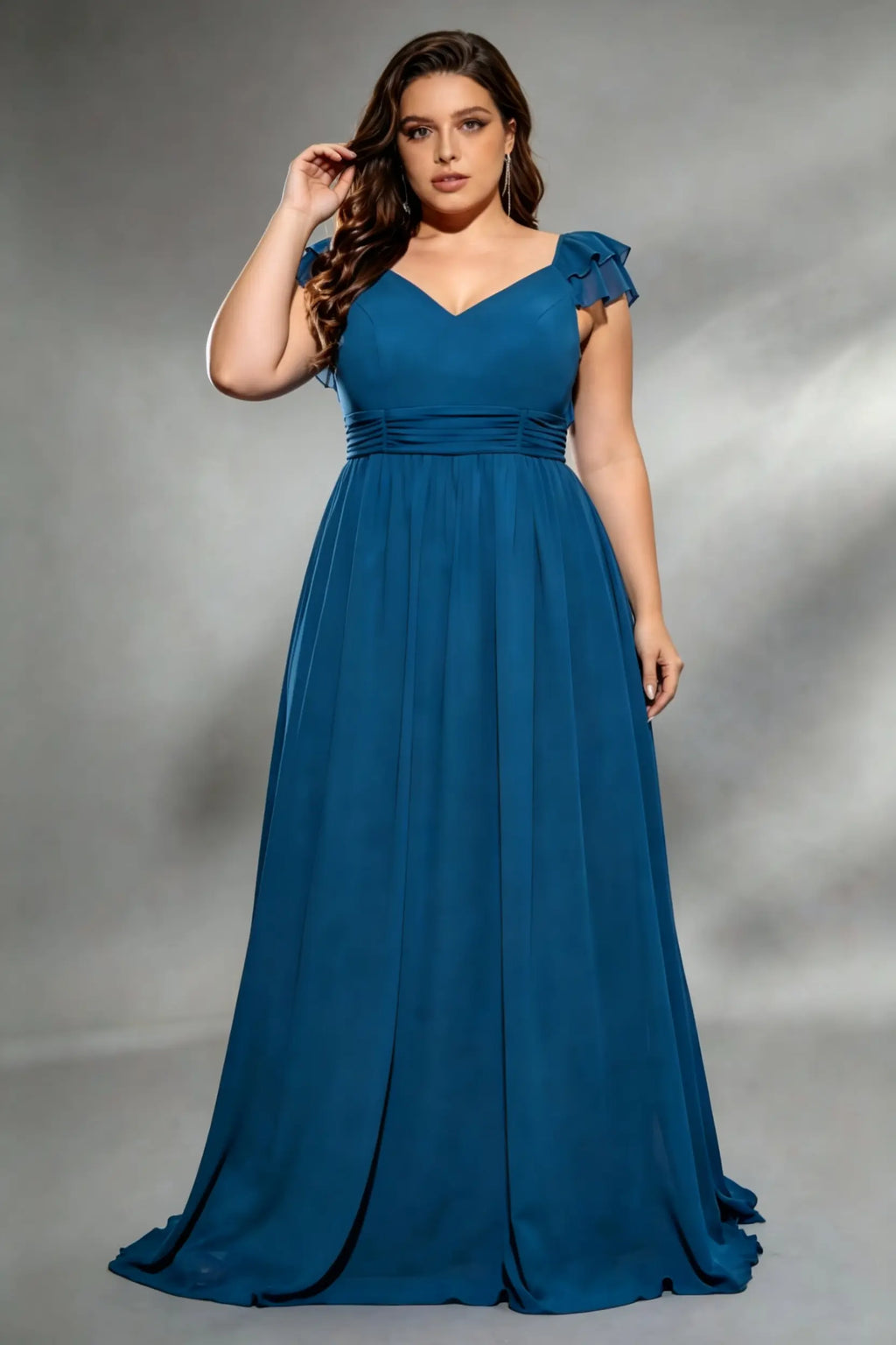 Curvy model wearing plus size navy v-neck teal blue chiffon maxi dress with cascading back ruffles