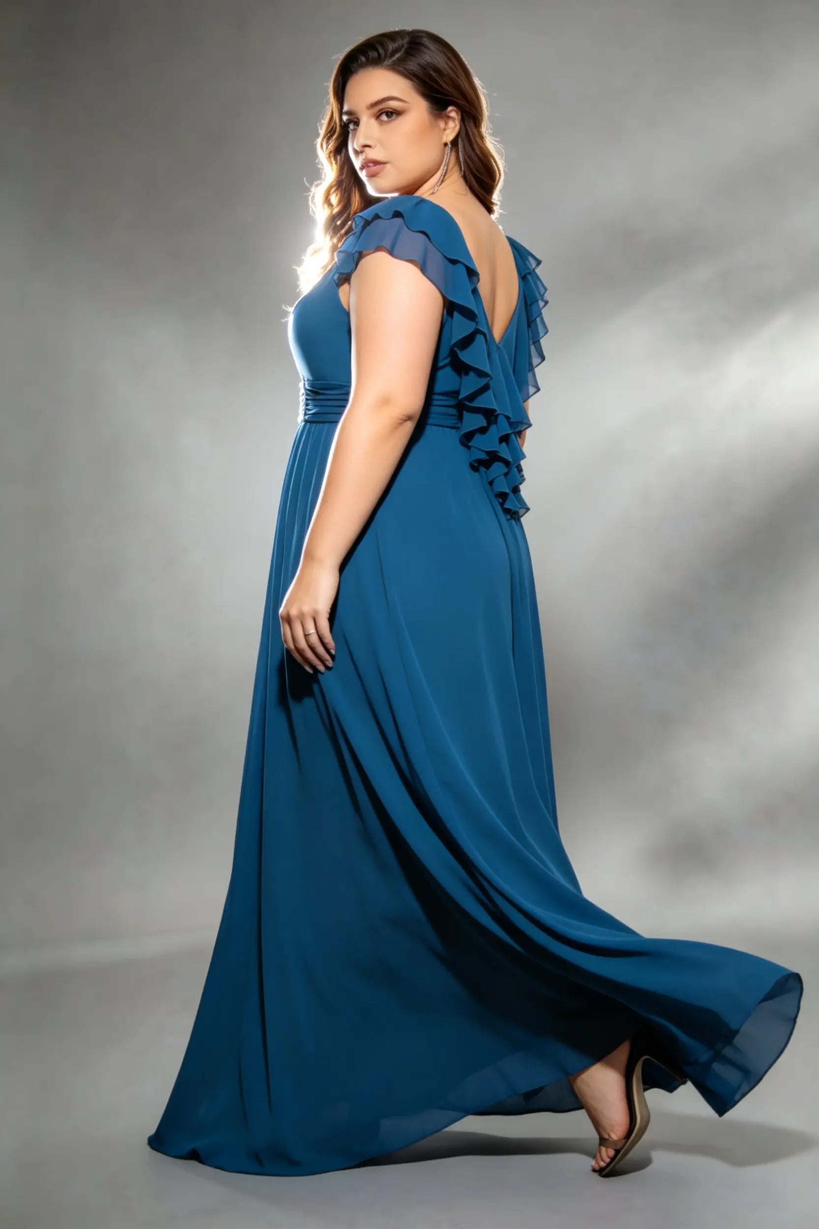 Curvy model wearing plus size navy v-neck teal blue chiffon maxi dress with cascading back ruffles