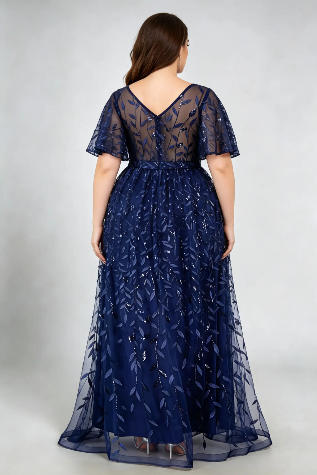 Curvy model wearing plus size navy sequined leaf flutter sleeve evening gown - elegant a-line prom & wedding guest maxi dress