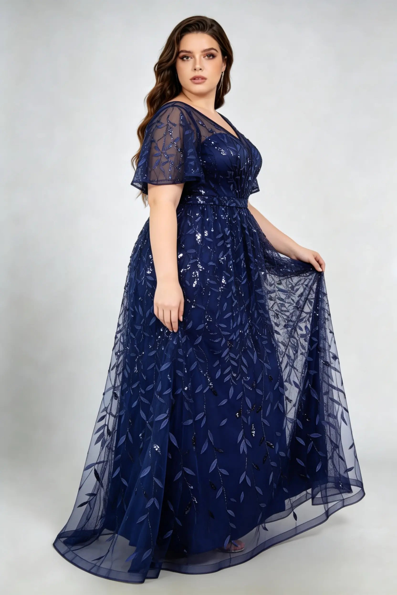 Curvy model wearing plus size navy sequined leaf flutter sleeve evening gown - elegant a-line prom & wedding guest maxi dress