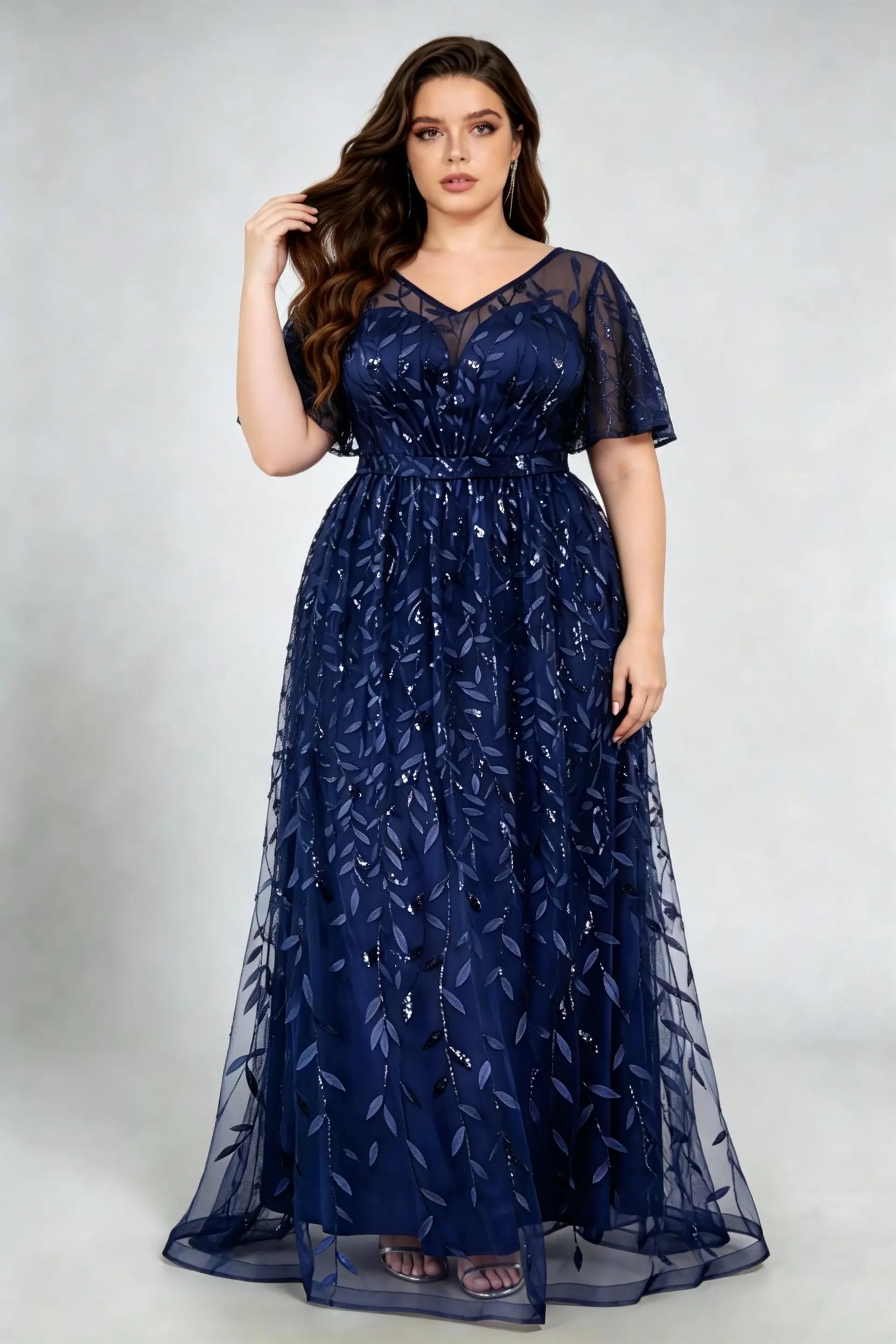 Curvy model wearing plus size navy sequined leaf flutter sleeve evening gown - elegant a-line prom & wedding guest maxi dress