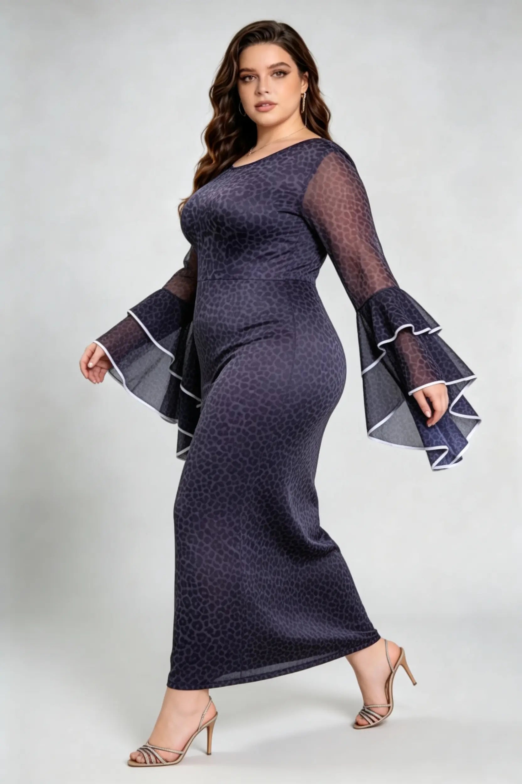 Curvy model wearing plus size black leopard print bodycon maxi dress with dramatic bell sleeves