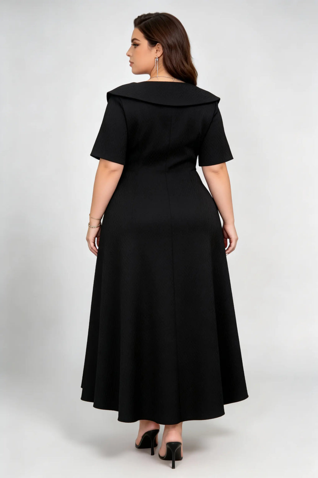 Curvy model wearing plus size black double-breasted asymmetric hem maxi dress, notched lapel short sleeve textured elegant workwear spring dress