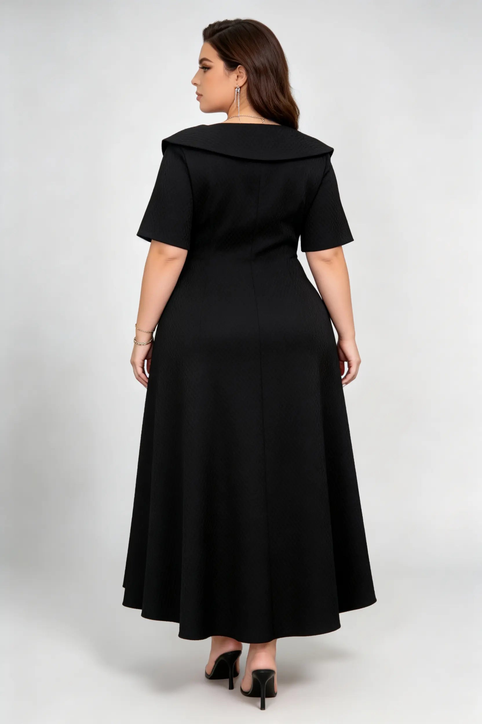 Curvy model wearing plus size black double-breasted asymmetric hem maxi dress, notched lapel short sleeve textured elegant workwear spring dress