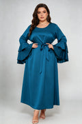 Curvy model wearing plus size teal blue satin maxi dress, tiered pearl flare sleeve round neck belted elegant evening dress