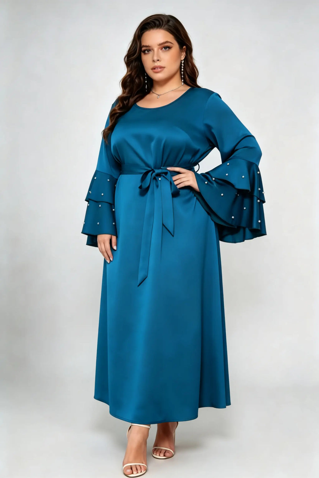 Curvy model wearing plus size teal blue satin maxi dress, tiered pearl flare sleeve round neck belted elegant evening dress