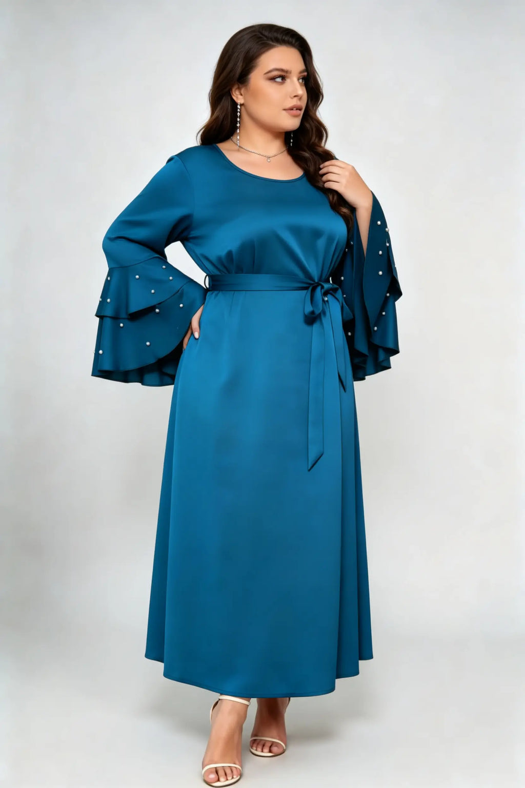 Curvy model wearing plus size teal blue satin maxi dress, tiered pearl flare sleeve round neck belted elegant evening dress