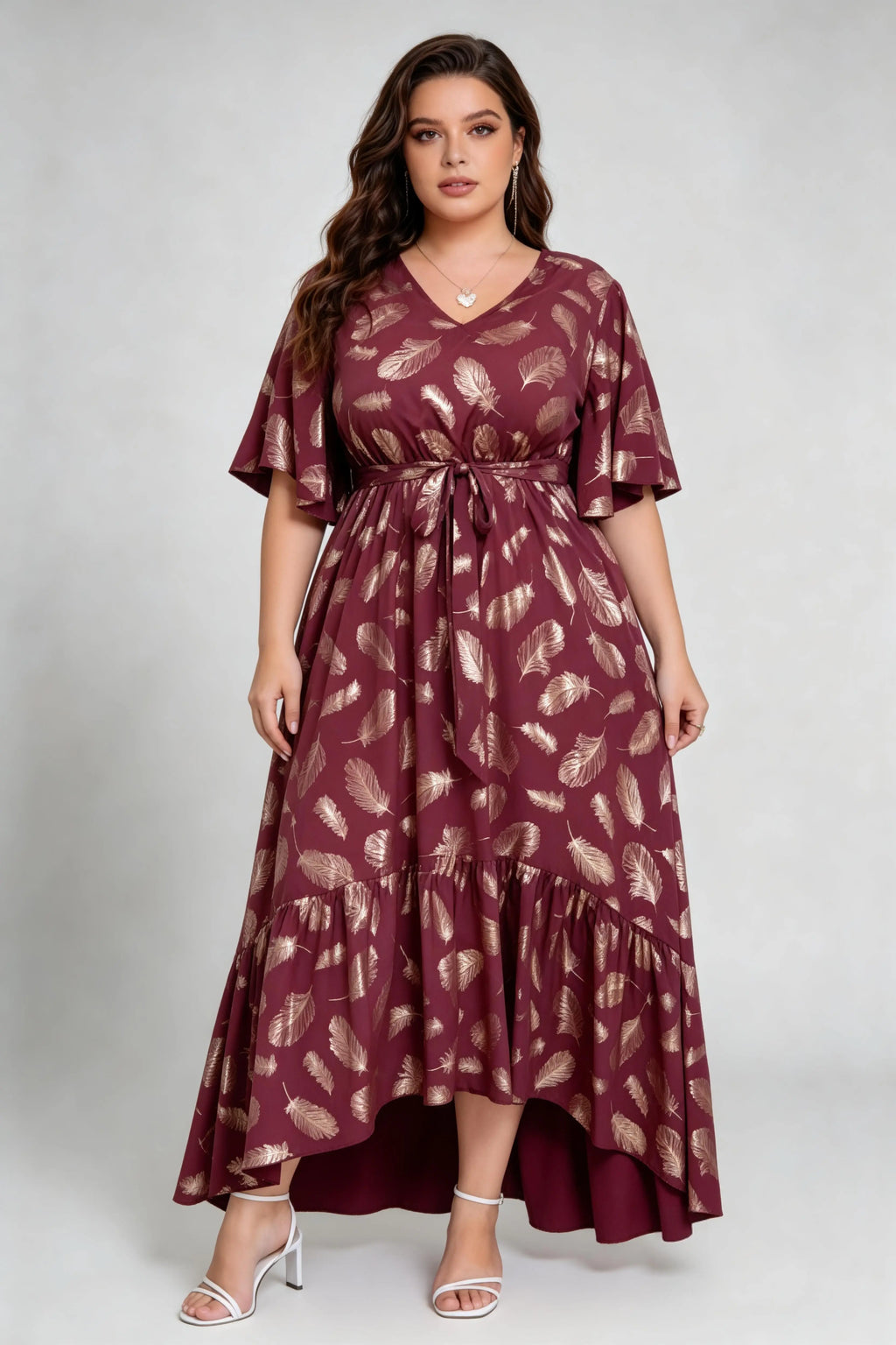 Curvy model wearing plus size wine red gold foil feather print maxi dress, v-neck flare sleeve high-low hem belted elegant summer dress