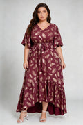 Curvy model wearing plus size wine red gold foil feather print maxi dress, v-neck flare sleeve high-low hem belted elegant summer dress