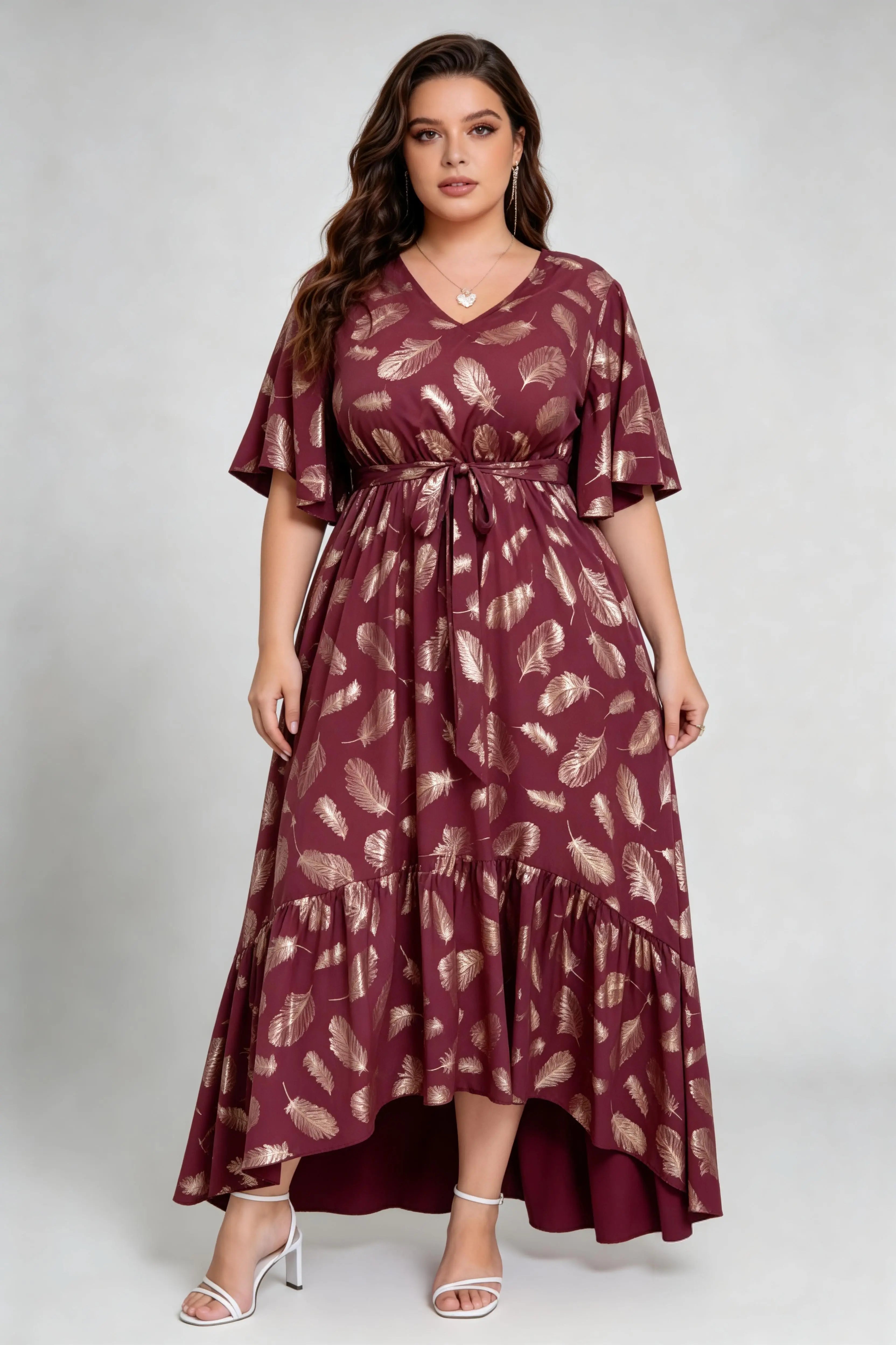 Curvy model wearing plus size wine red gold foil feather print maxi dress, v-neck flare sleeve high-low hem belted elegant summer dress
